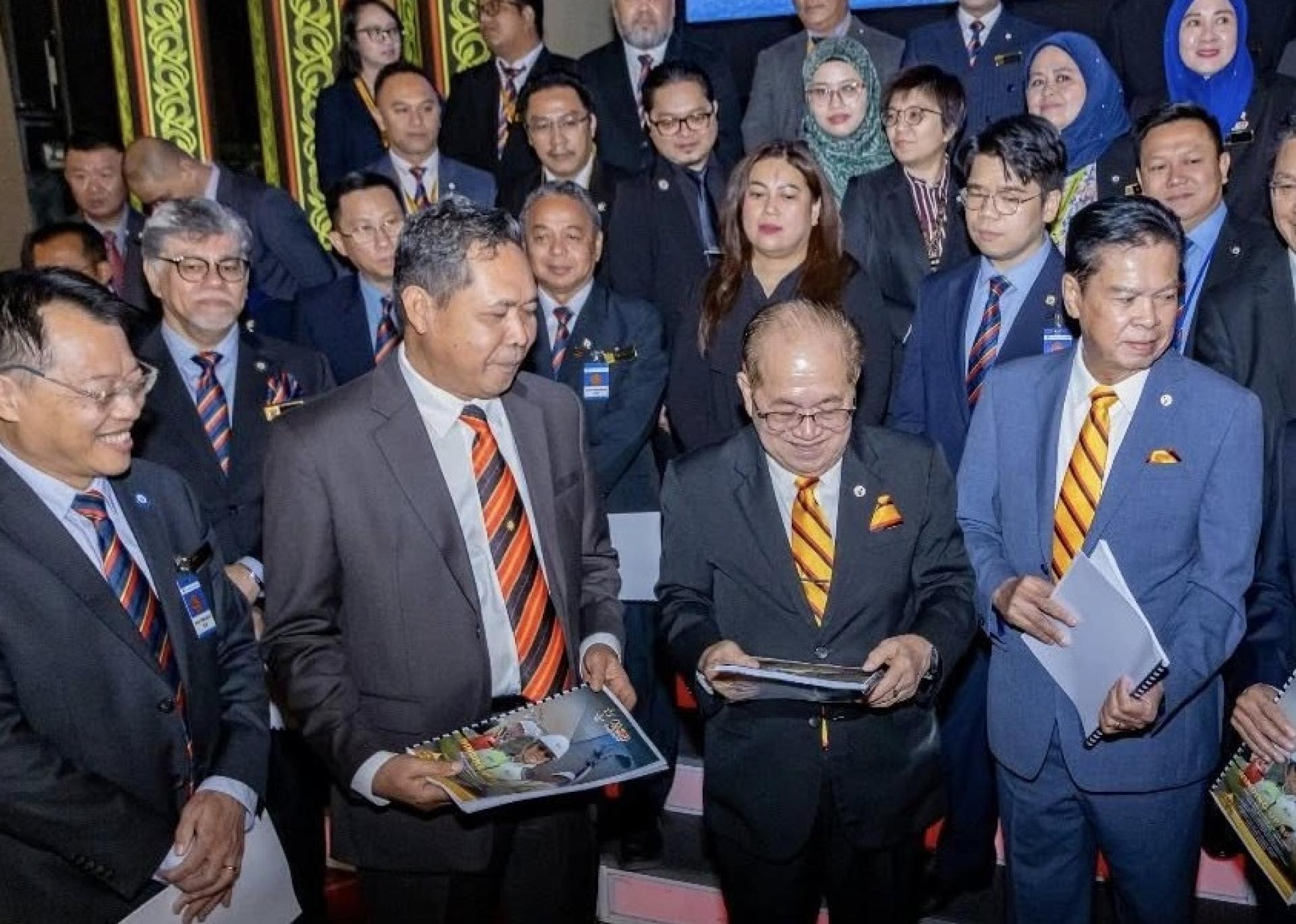 拿督阿玛道格拉斯（右2）与其部门职员们展示总结文件并合影。