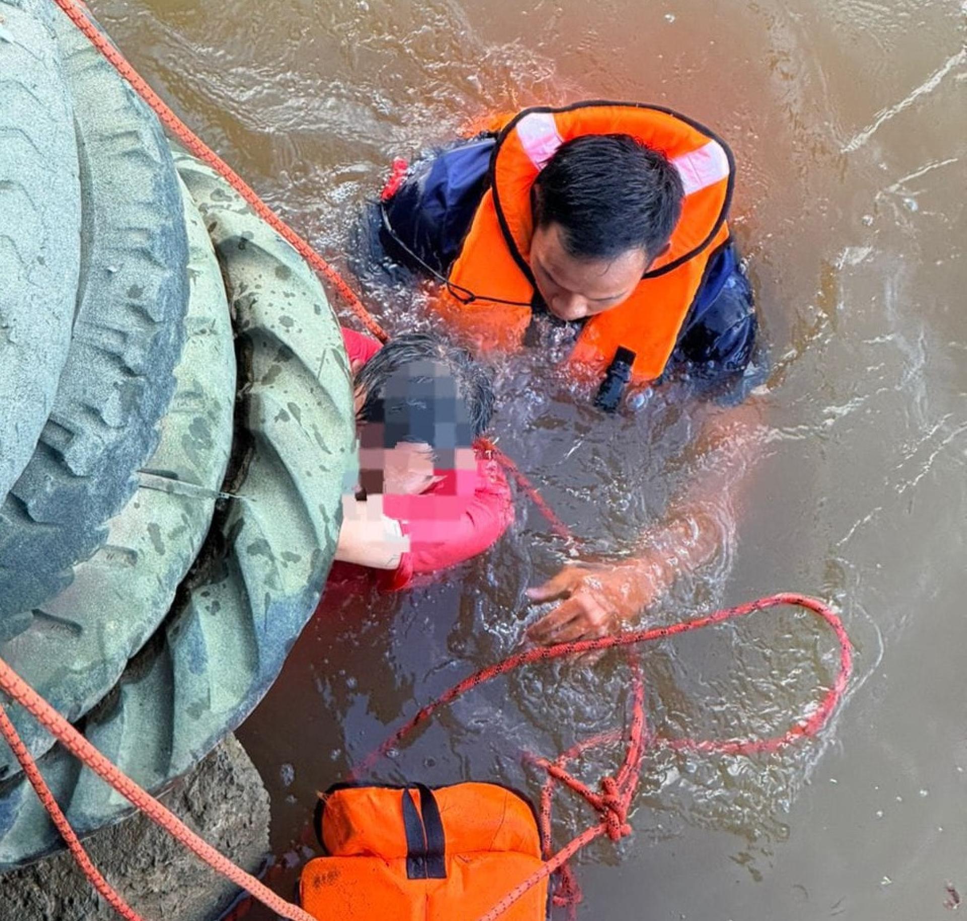 救援人员在河中为落水男子穿上救生衣，并成功将其拉上岸。
