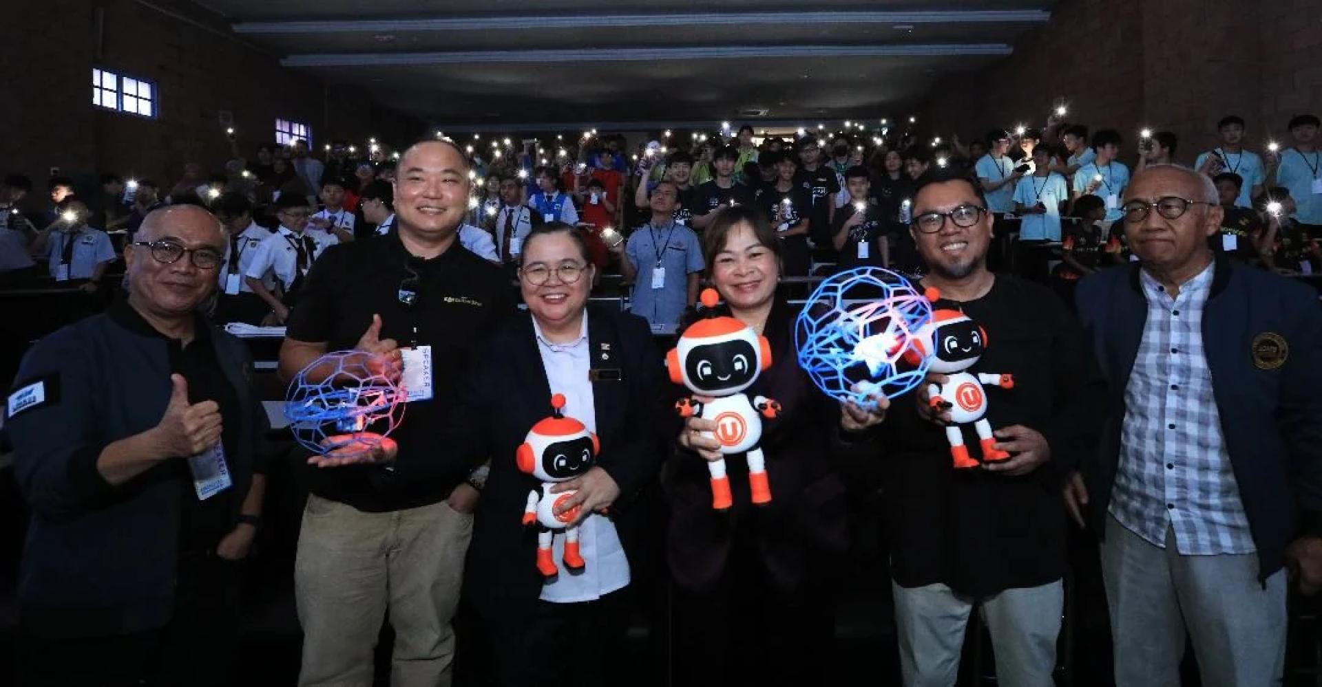 KENANGAN... Shuhaimi (kiri) dan Anielia Siam (tiga dari kiri) merakam gambar bersama-sama peserta pada RoboMaster 2025, di sini, hari ini.