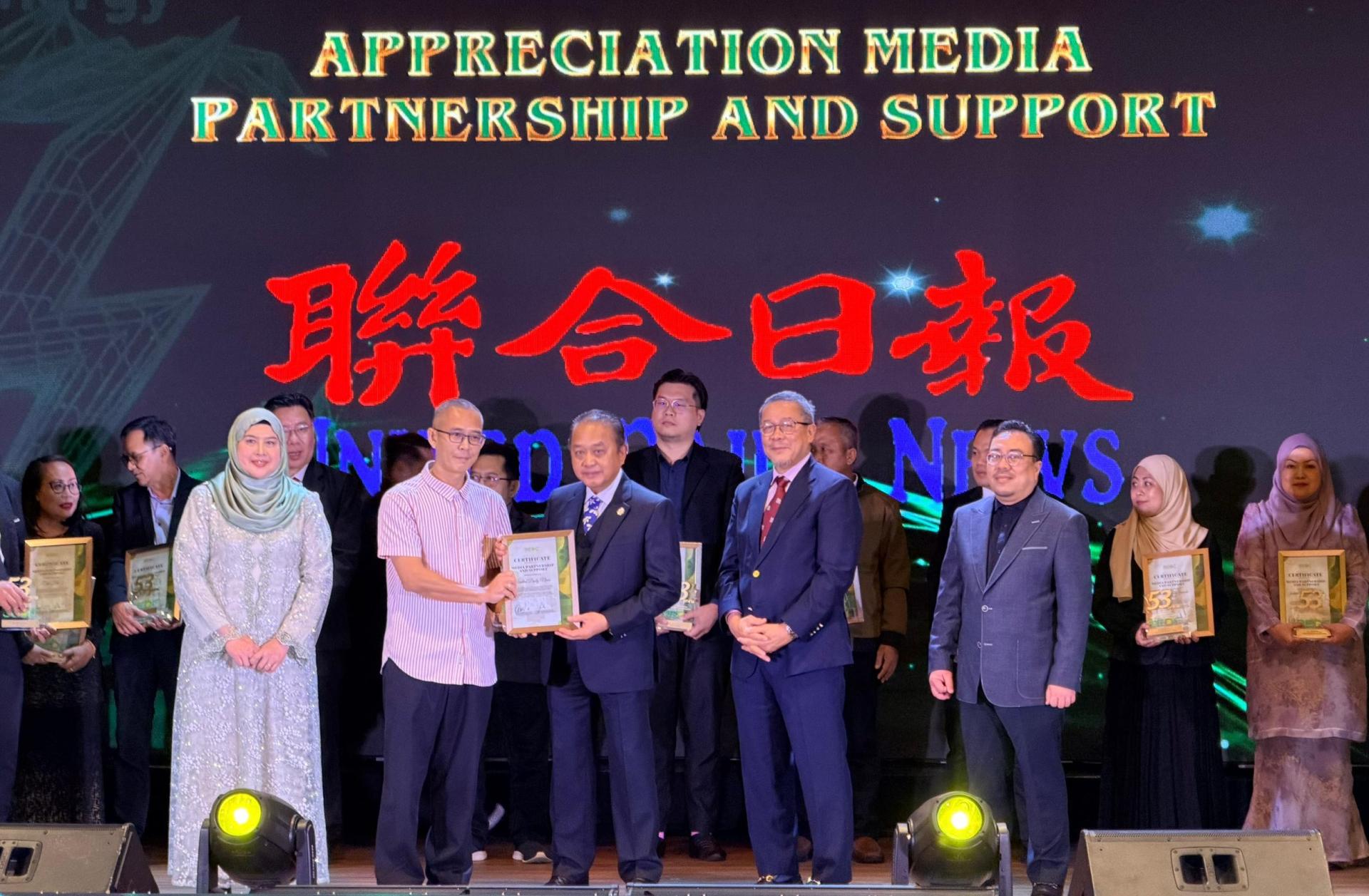 砂经济发展机构主席丹斯里拿督阿玛阿都阿兹（前中）颁发感谢状给本报《联合日报》，并由代表陈卓伟接收。