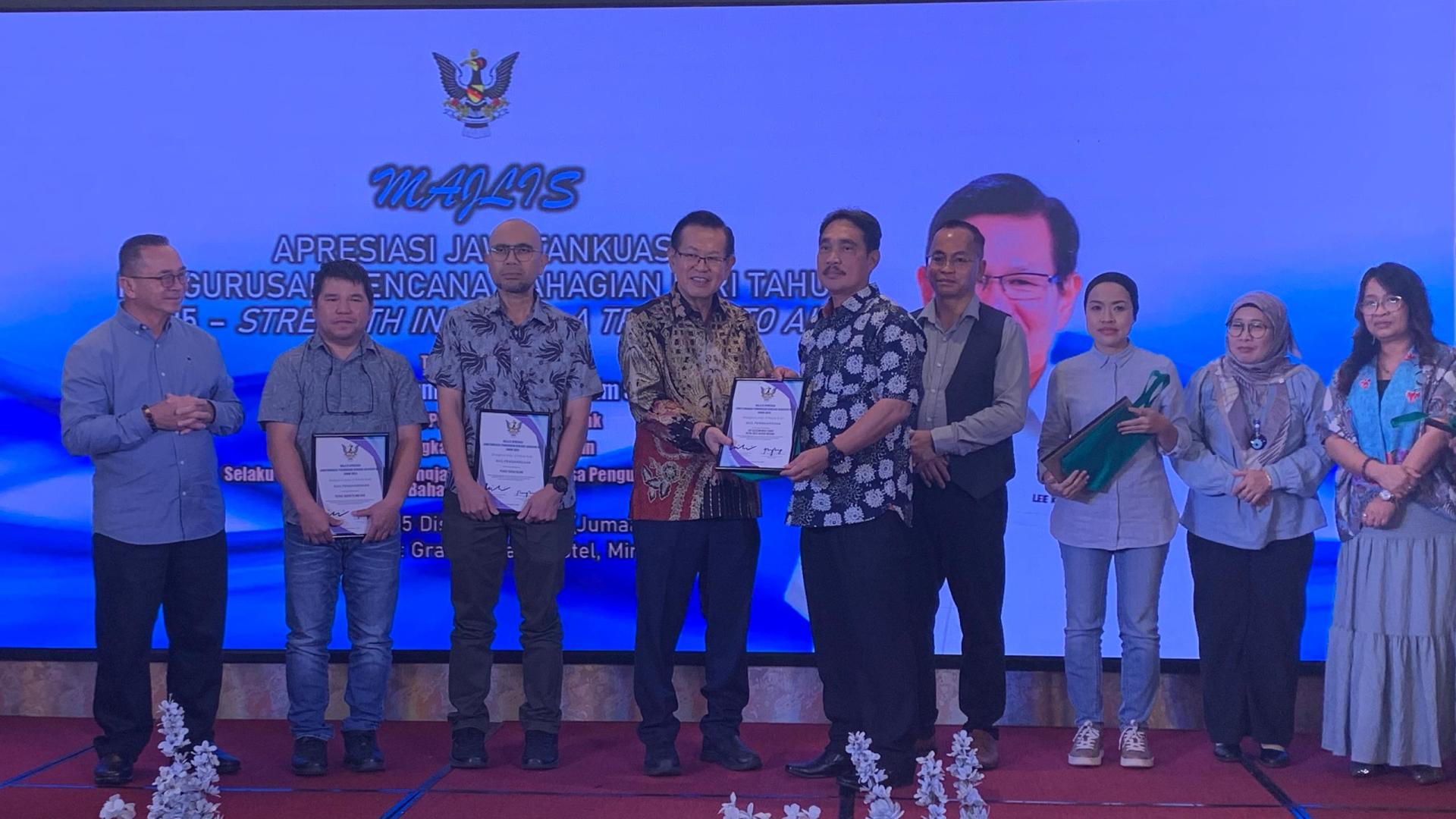 拿督斯里李景胜（左4）颁发感谢状予前美里警区主任亚历森助理总监时摄。