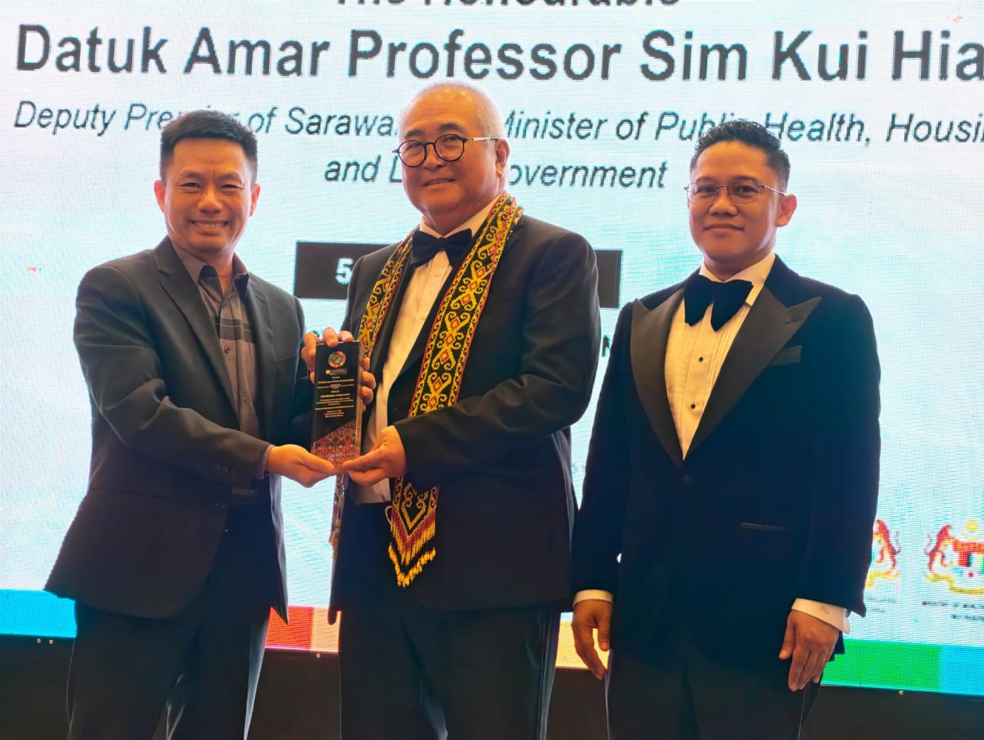 武常翠教授（左1）赠送纪念品予拿督阿玛沈桂贤代表美里市长兼埔奕区议员俞小珊时摄。