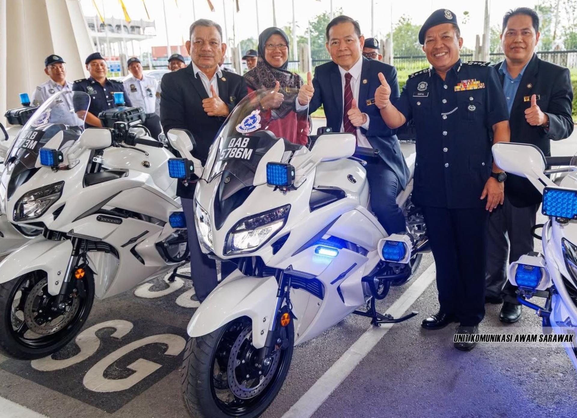 砂拉越副政府秘书（经济策划与发展）拿督斯里莫哈末阿都拉再德尔(中)座上高性能摩托车合影。右2为砂副警察总监赛夫里赞。