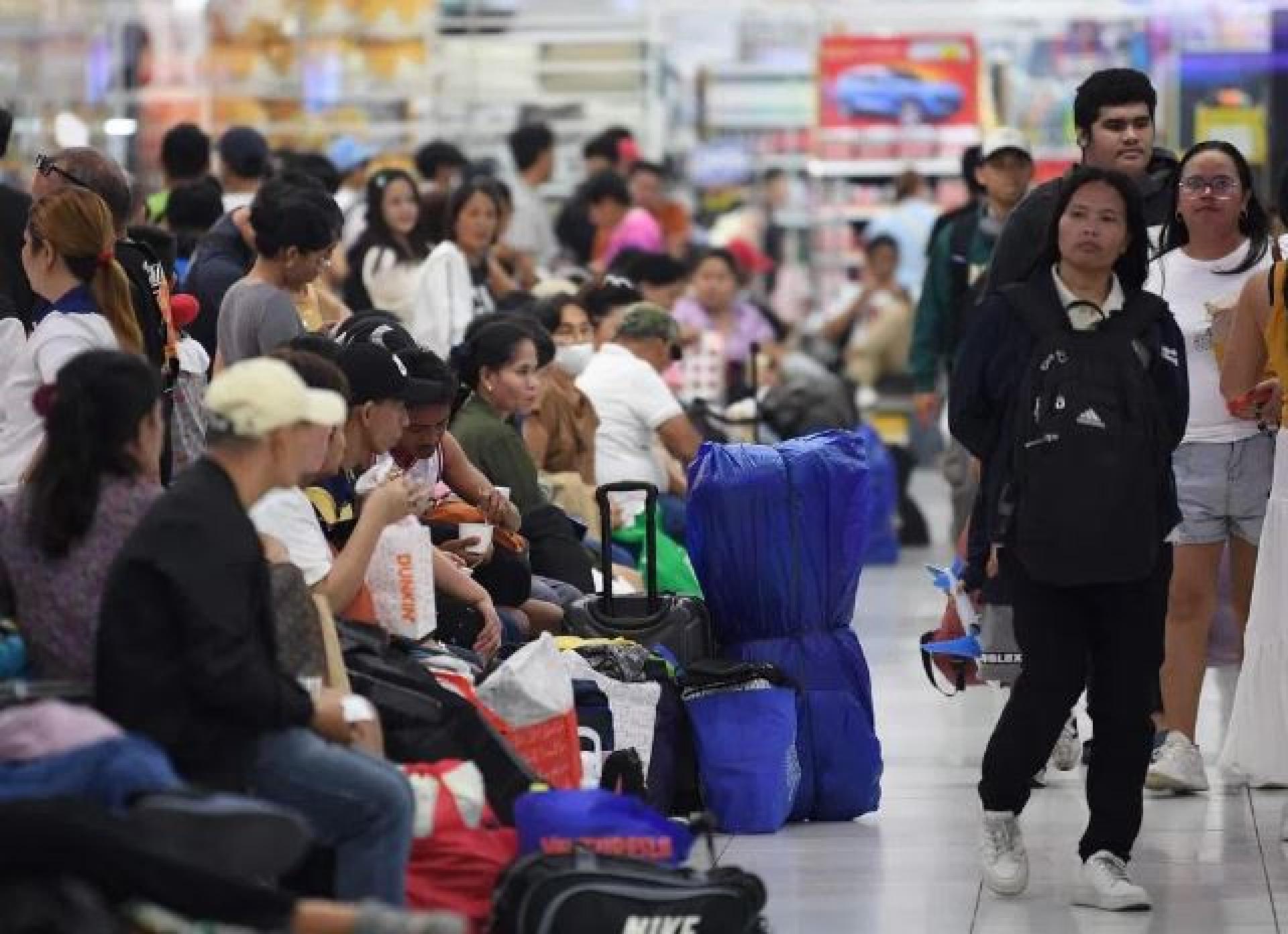 菲律宾11月通胀率降至1.5%，为今年8月以来首次回落。图为首都马尼拉巴士终站，乘客正等候巴士。