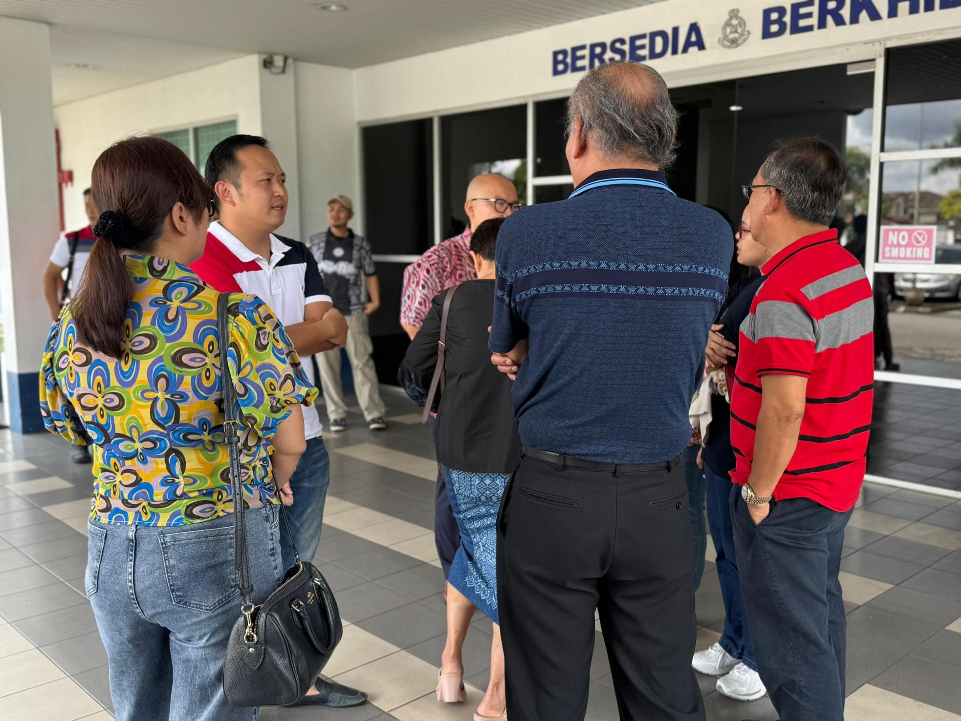 江峰年与受害者在警局外交流。