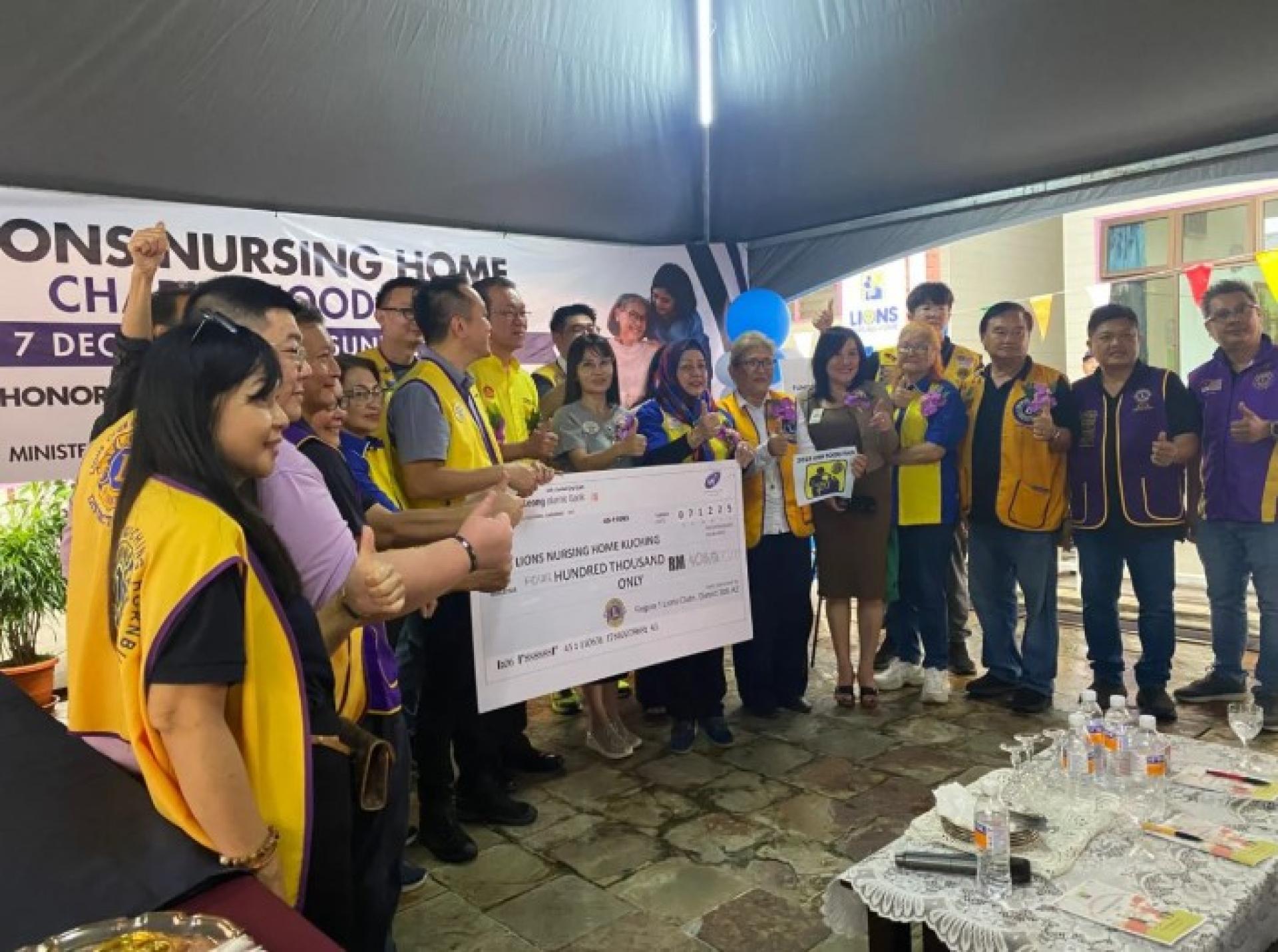 叶耀星（中）在古晋出席2025年度狮子会养老院慈善美食节时，将支票交予狮子会养老院代表。