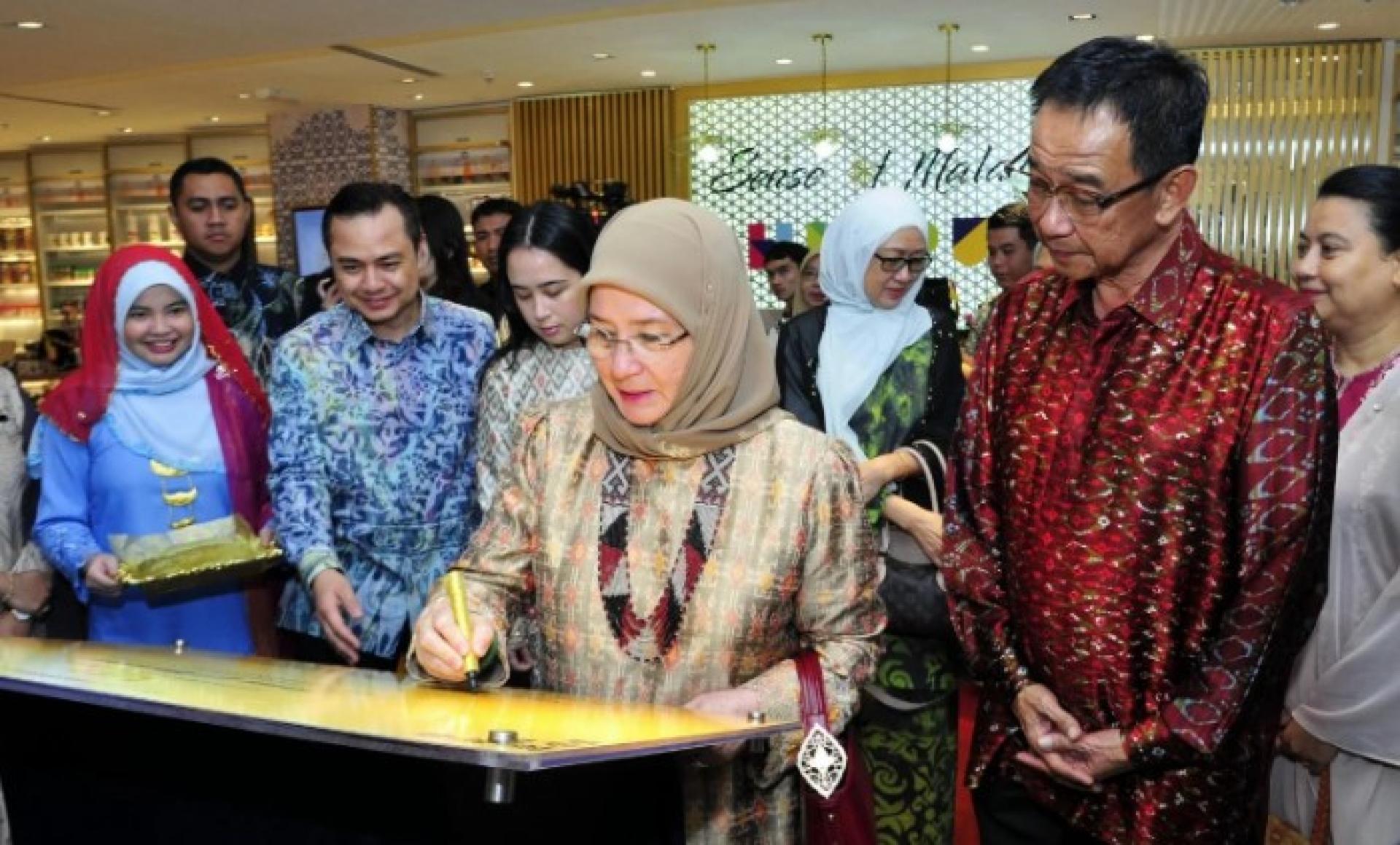 敦阿兹莎（中）在古晋国际机场为SOM分店开幕牌匾签名，左起为Shahren Yusri、Tengku Puteri Raja Tengku Puteri Jihan Azizah ‘Athiyatullah Al-Sultan Abdullah Ri’ayatuddin Al-Mustafa Billah Shah’及拿督斯里阿都卡林。