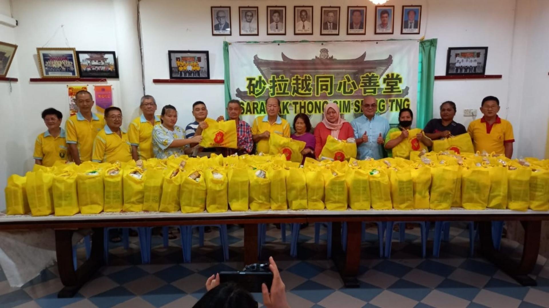 砂同心善堂配合三庆布施食品予弱势家庭。左7起为李锦璇、砂同心善堂主席黄国远、主宾薛华东的代表黄昭信等人派布施品予各族人士。