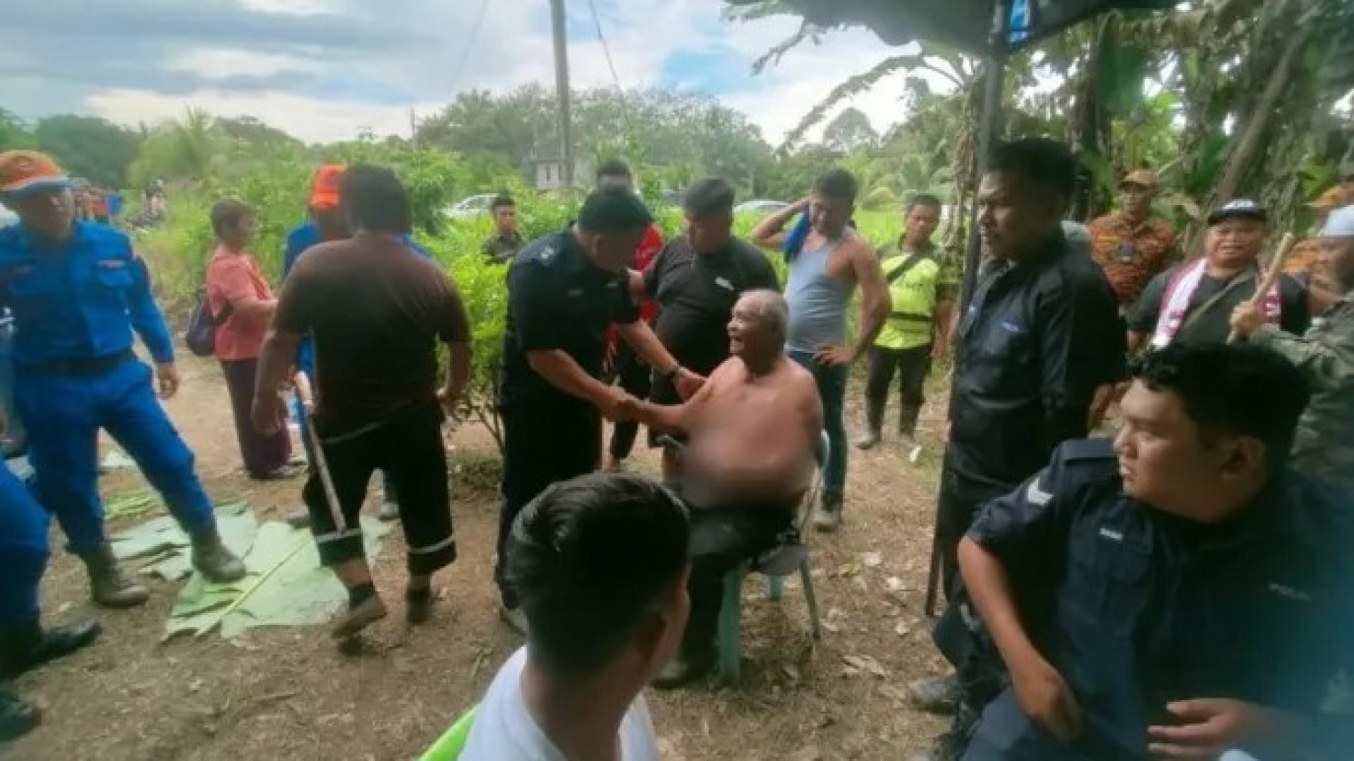 受害人（坐着）在2025年12月7日于林梦甘榜Merasam Darat获救后接受救援人员照料。