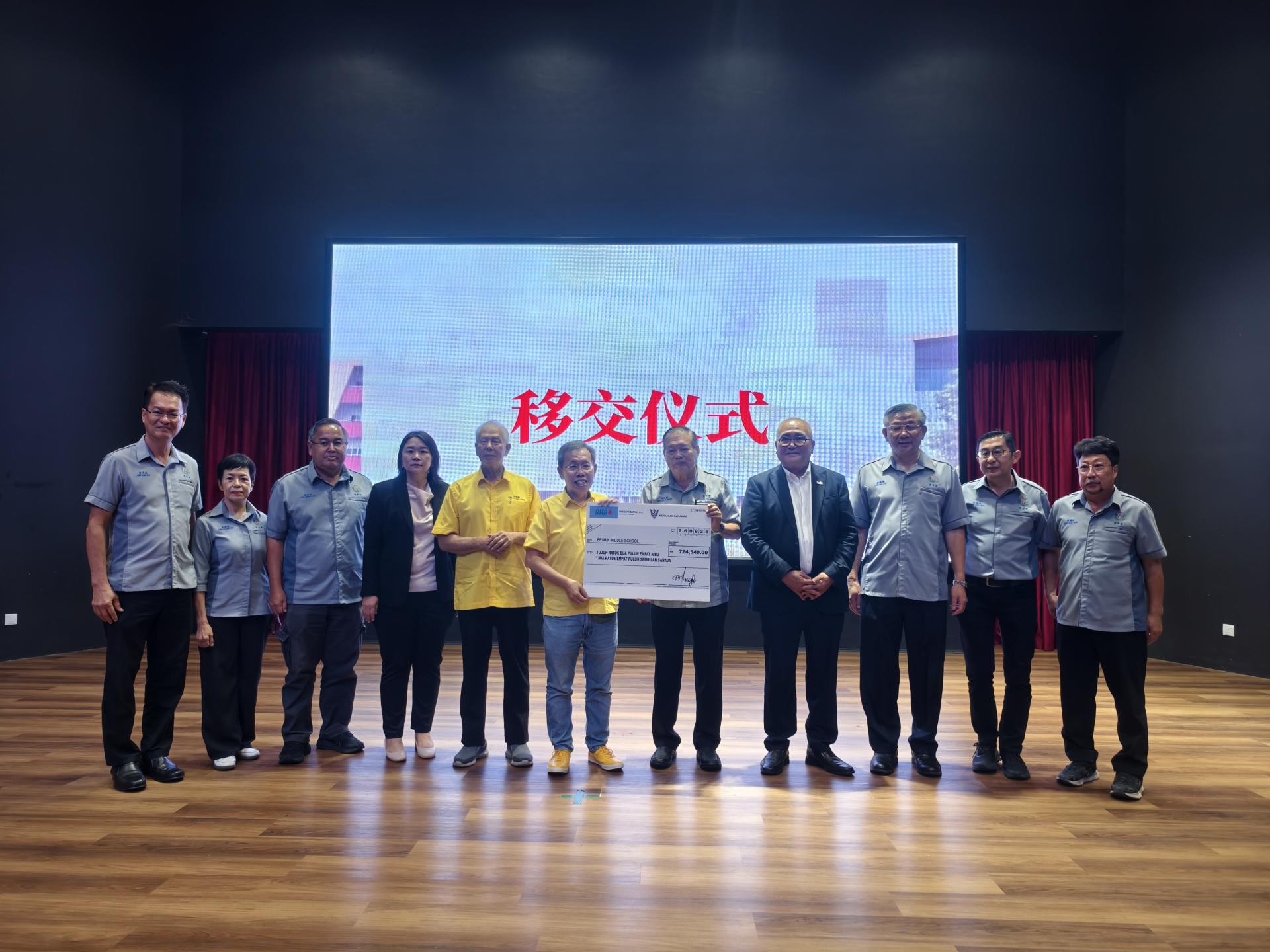 砂拉越副总理拿督阿玛沈桂贤（左6）移交2025年度砂拉越华文独立中学拨款72万4549令吉给美里培民中学，由署理董事长陈则胜接领。