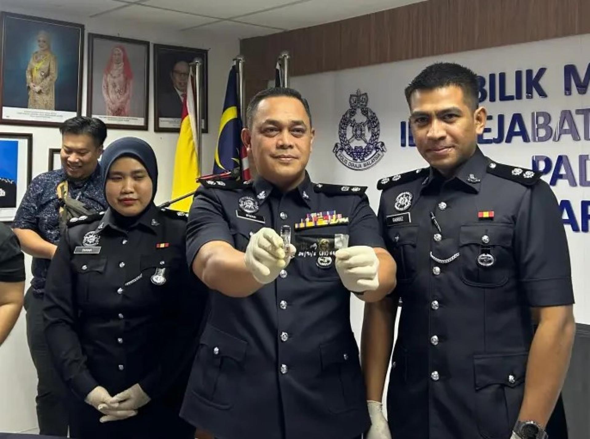 莫哈末伊尔万（中）在12月5日巴达旺区警察总部新闻发布会上展示查获的疑似毒液烟弹之一。