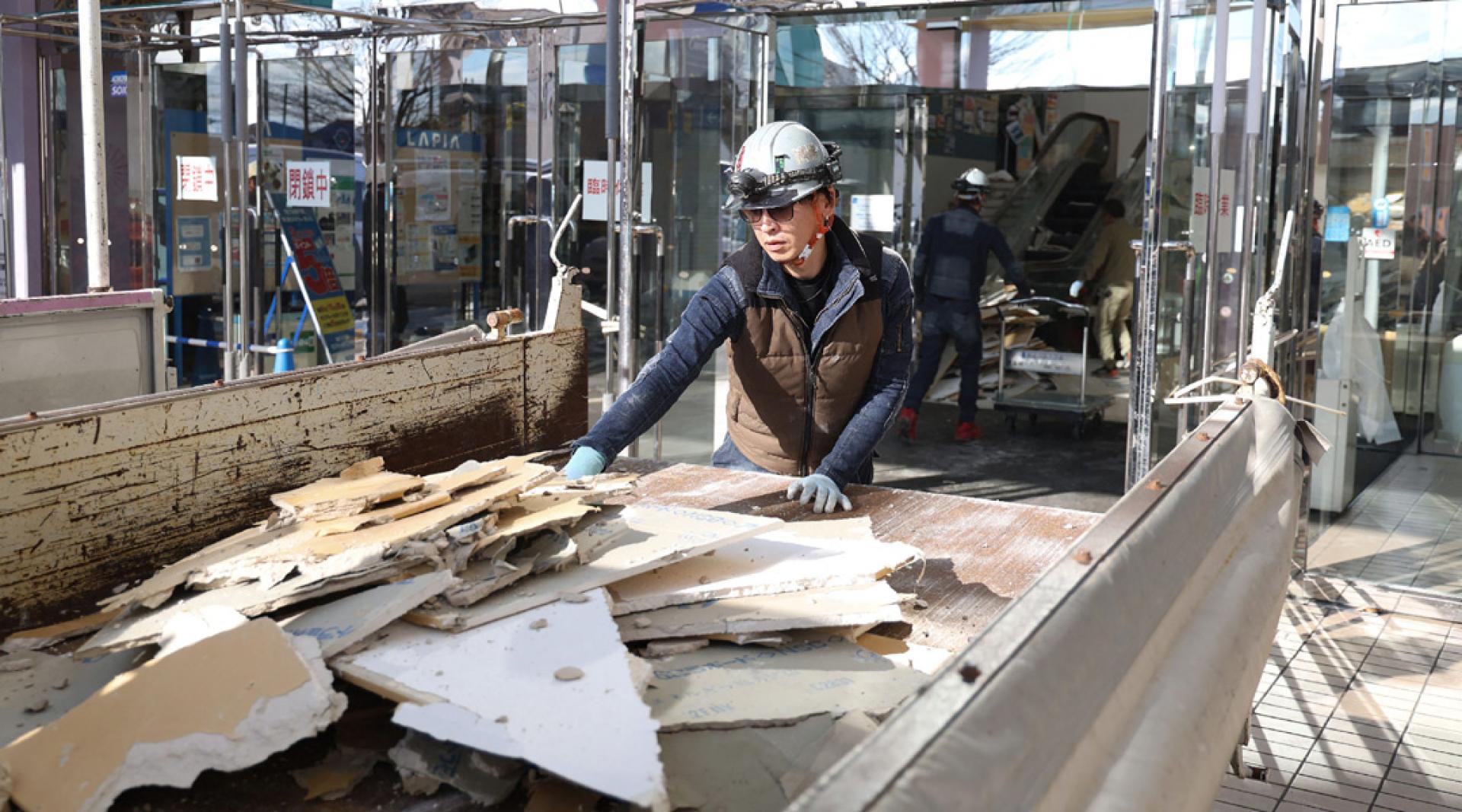 在青森县八户市一购物中心，工人展开灾后清理工作。