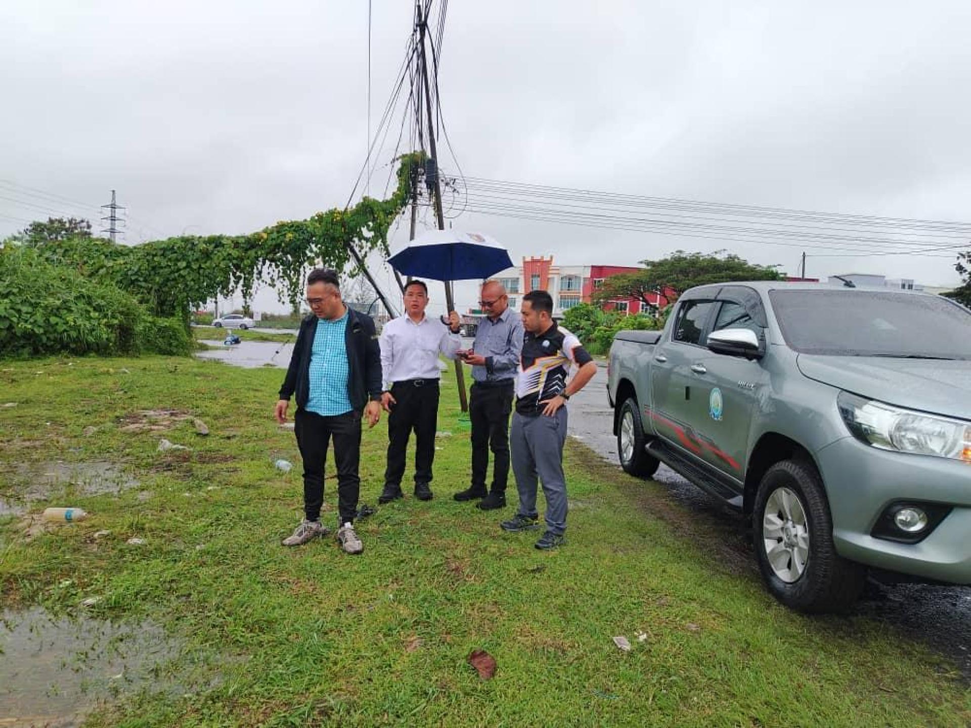 左起为美里市议员熊千雨与窦家雄前往美里的灾水地区巡视。