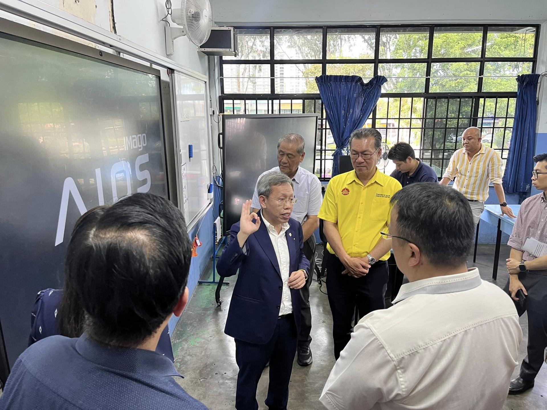 沈桂贤在参观智慧教室安装的教学器材。