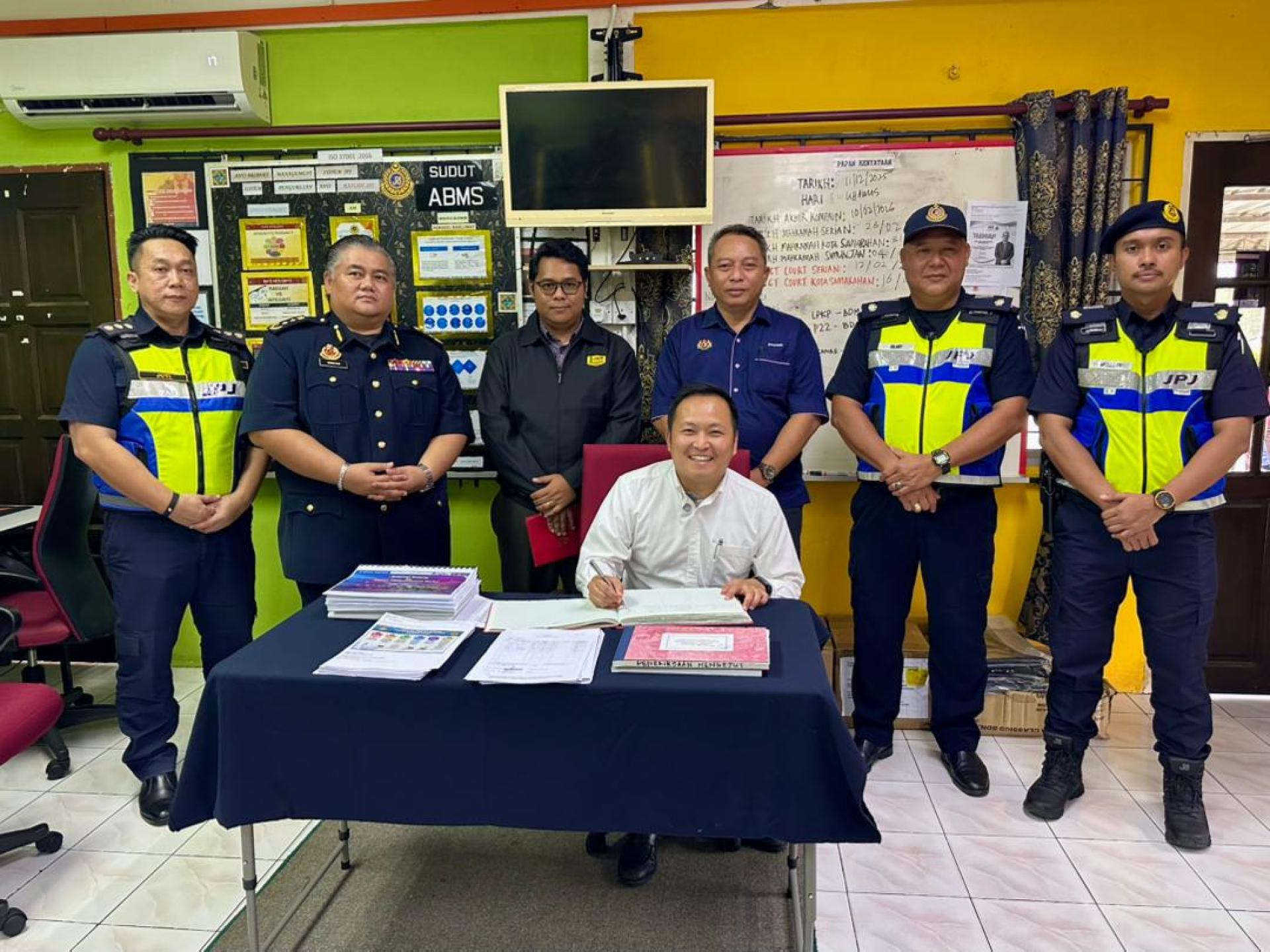 江峰年在签到簿子上签名留念。