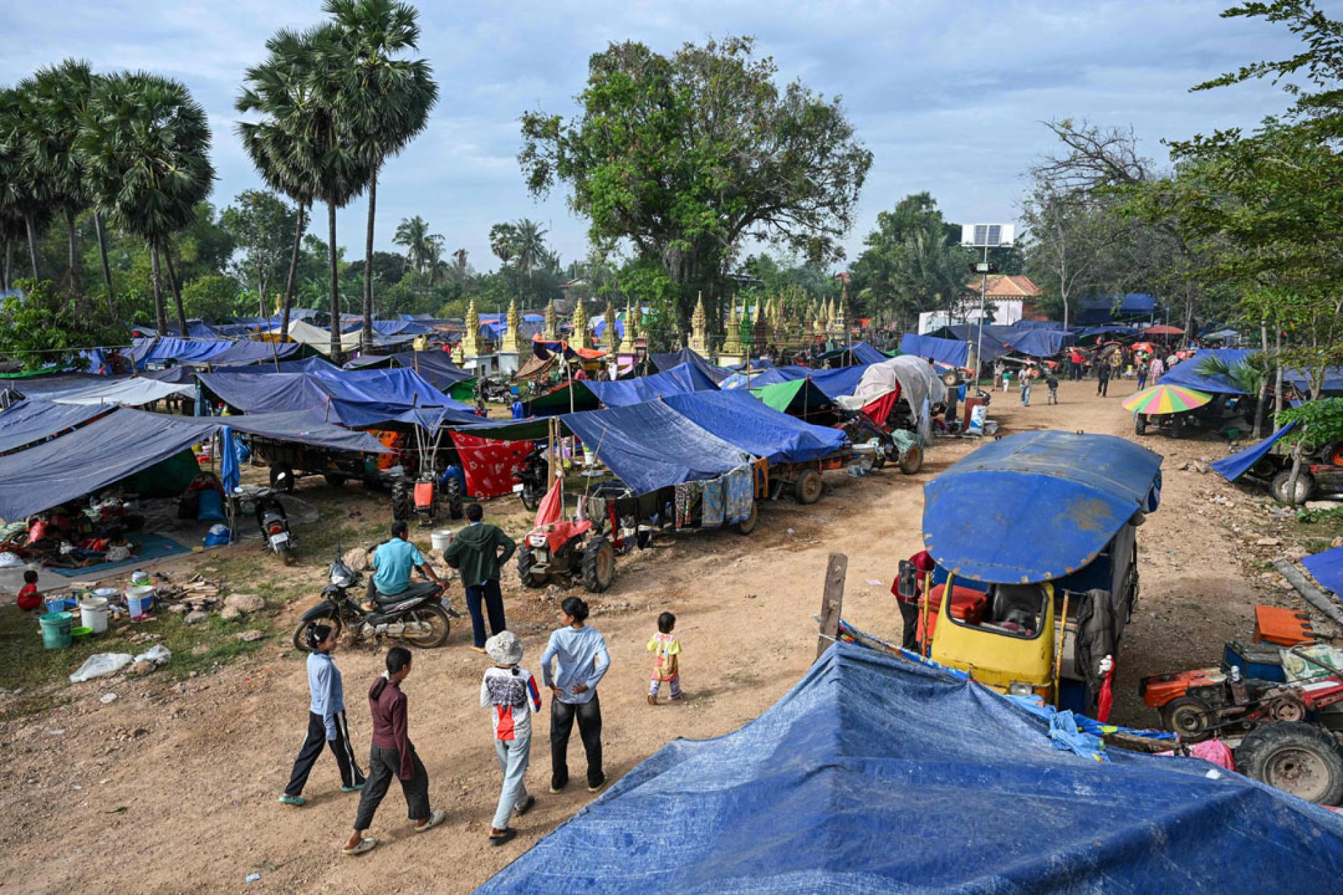 在柬埔寨暹粒省，流离失所的居民在一佛塔旁设立临时营地。