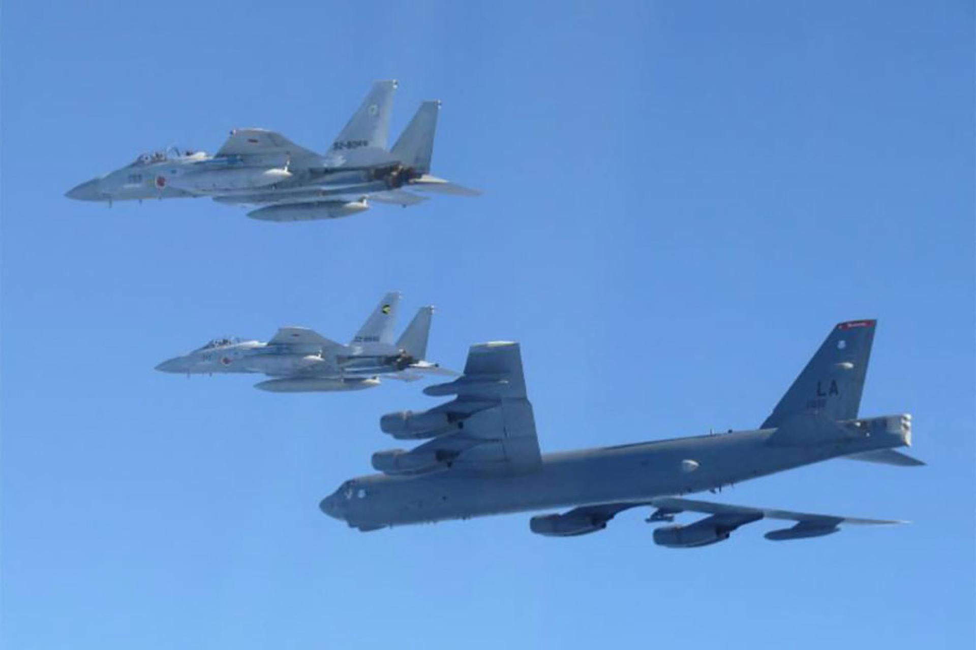 12月10日，一架美国空军B-52战略轰炸机（底部）和两架日本航空自卫队F-15战斗机正在日本海上进行联合演习。