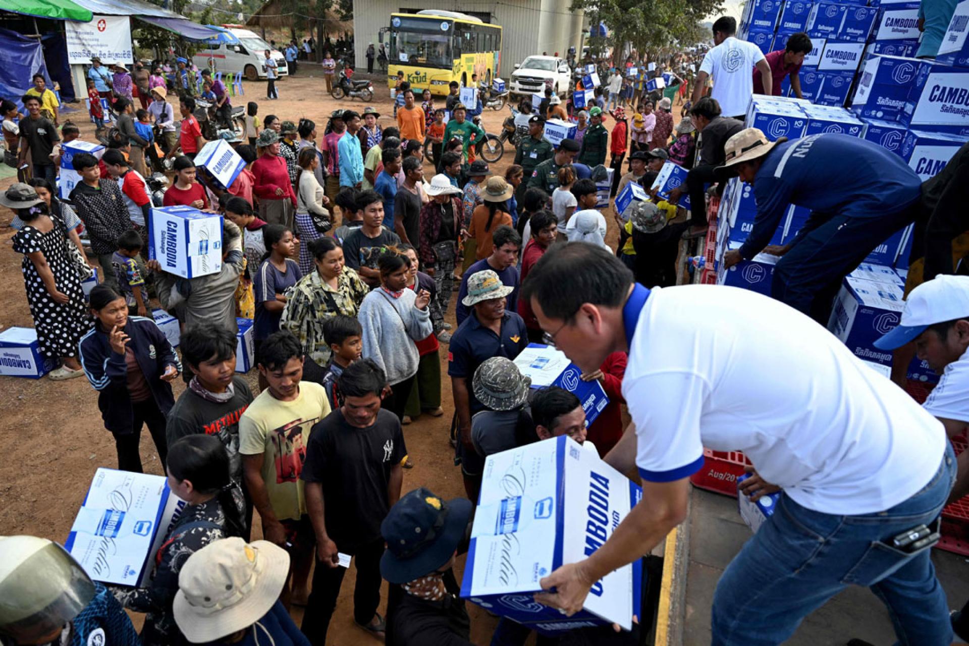 在柬埔寨奥多棉吉省的一个临时营地，工作人员11日将饮用水分发给流离失所者。