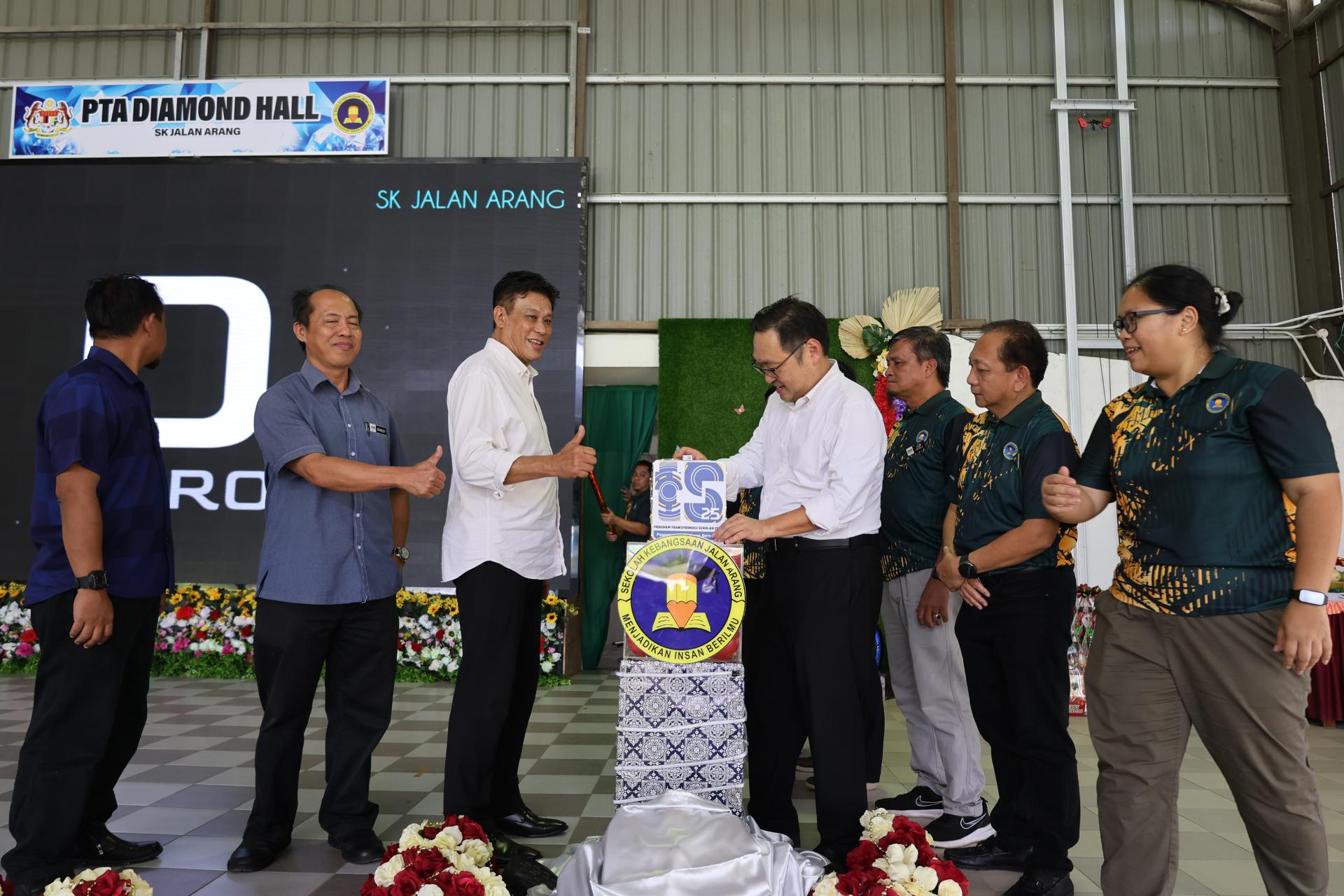 张健仁（中）在主办当局的陪同下，为礼堂LED电子屏幕主持推展仪式。