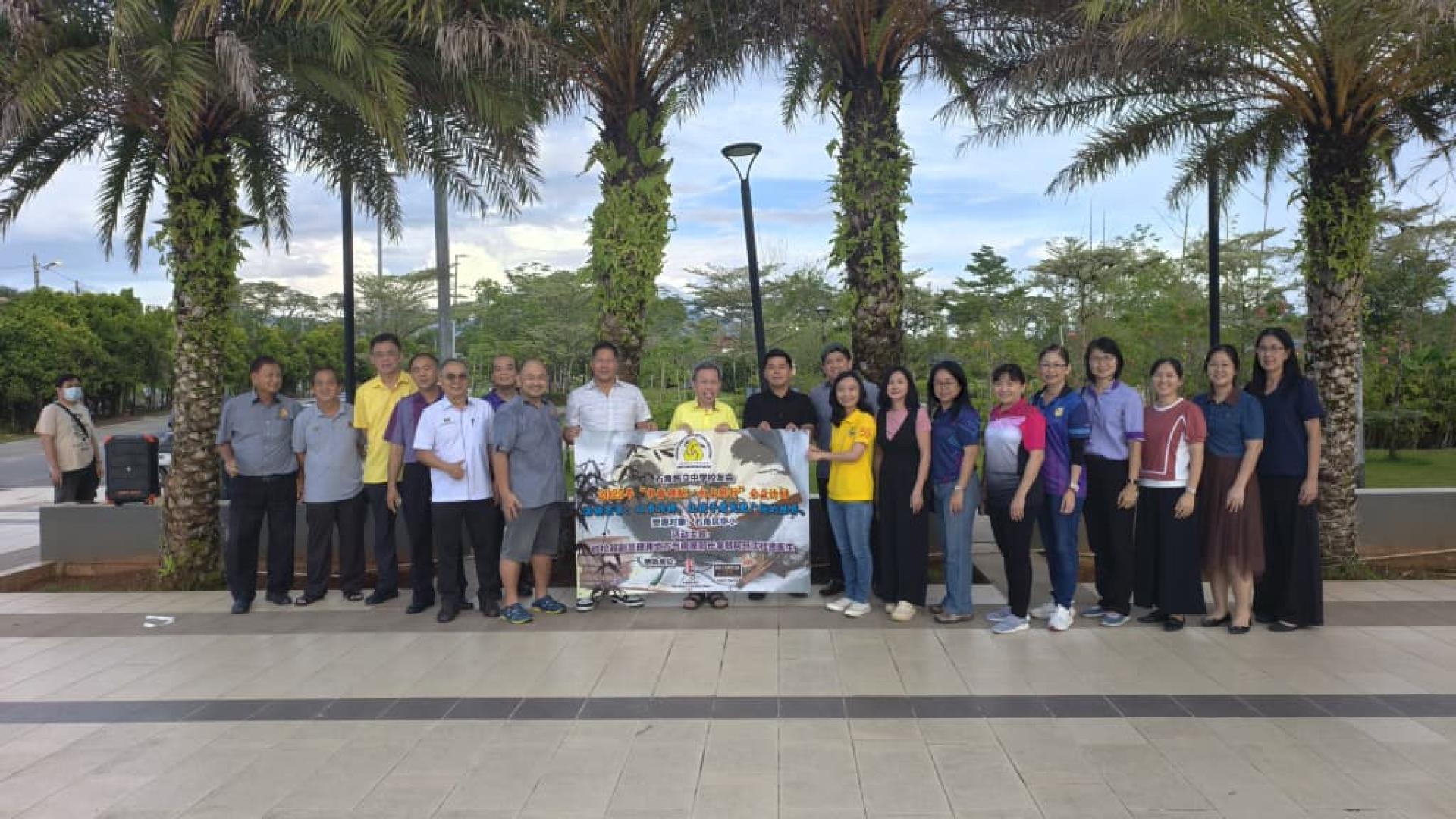 砂拉越副总理拿督阿玛沈桂贤医生(中），见证总赞助商利安集团董事本曼查陈君义（左8）与大食堂代表 Calvin Keong（右11）将书包移交给石角区华小校长。左3为活动嘉宾巴达旺市议会主席陈开，右9者为砂拉越总理署政治秘书许德婉。