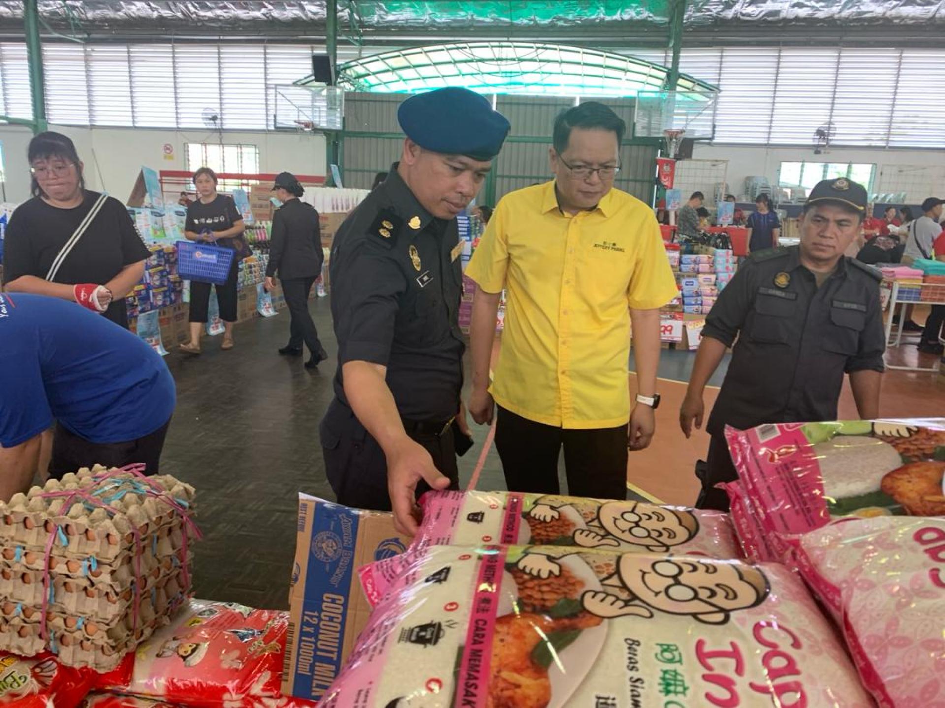 砂拉越交通部长拿督斯里李景胜的代表彭小菶（中）前往美里廉律中学礼堂视察“慈悯销售流动计划”活动商品。