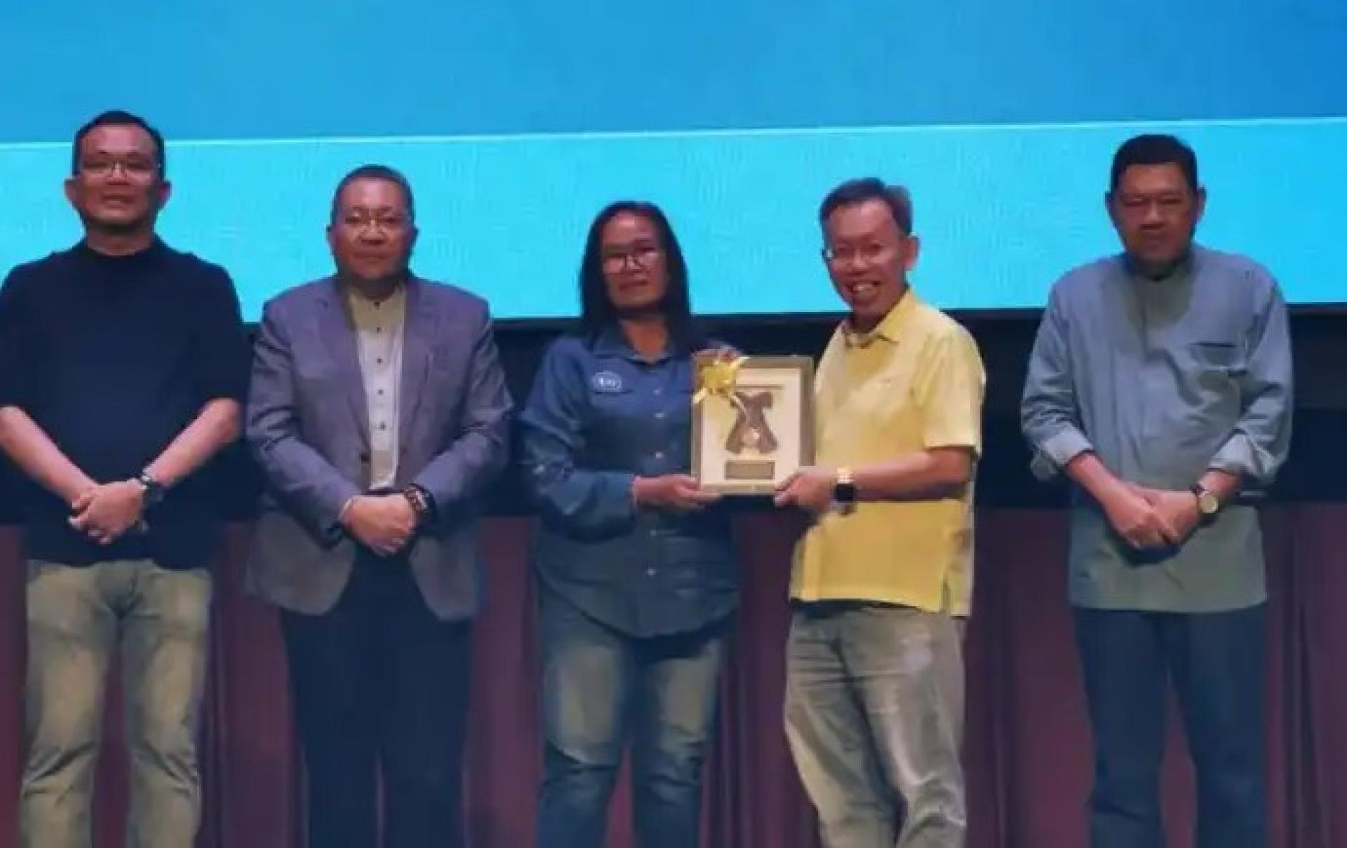 沈桂贤医生（右2）在2025年12月14日举行的MBKS年度晚宴上，向一名荣休职员颁发表扬牌。