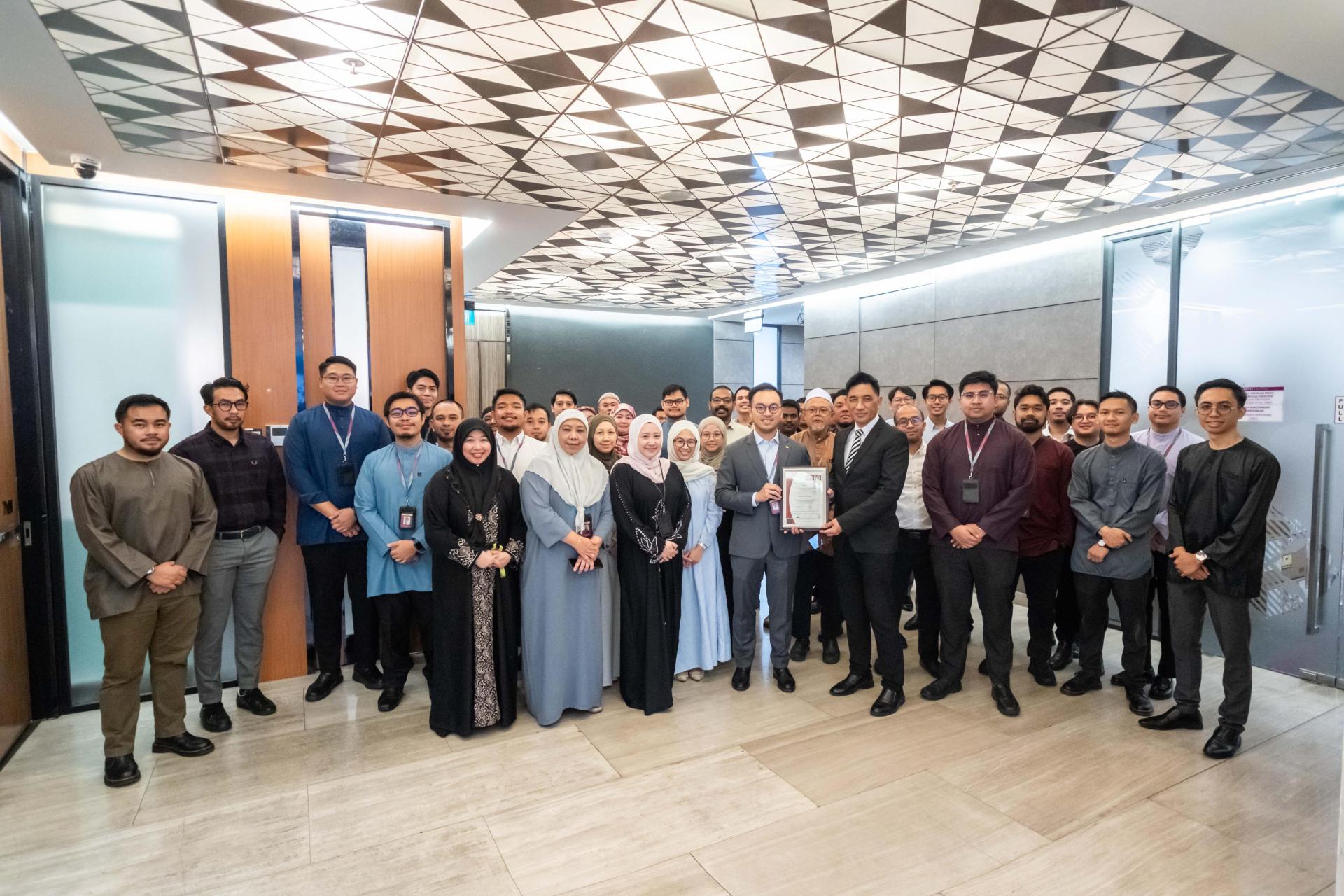 汶莱伊斯兰银行首席执行官朱奈迪与员工展示ISO 27001:2022信息安全管理体系（ISMS）认证