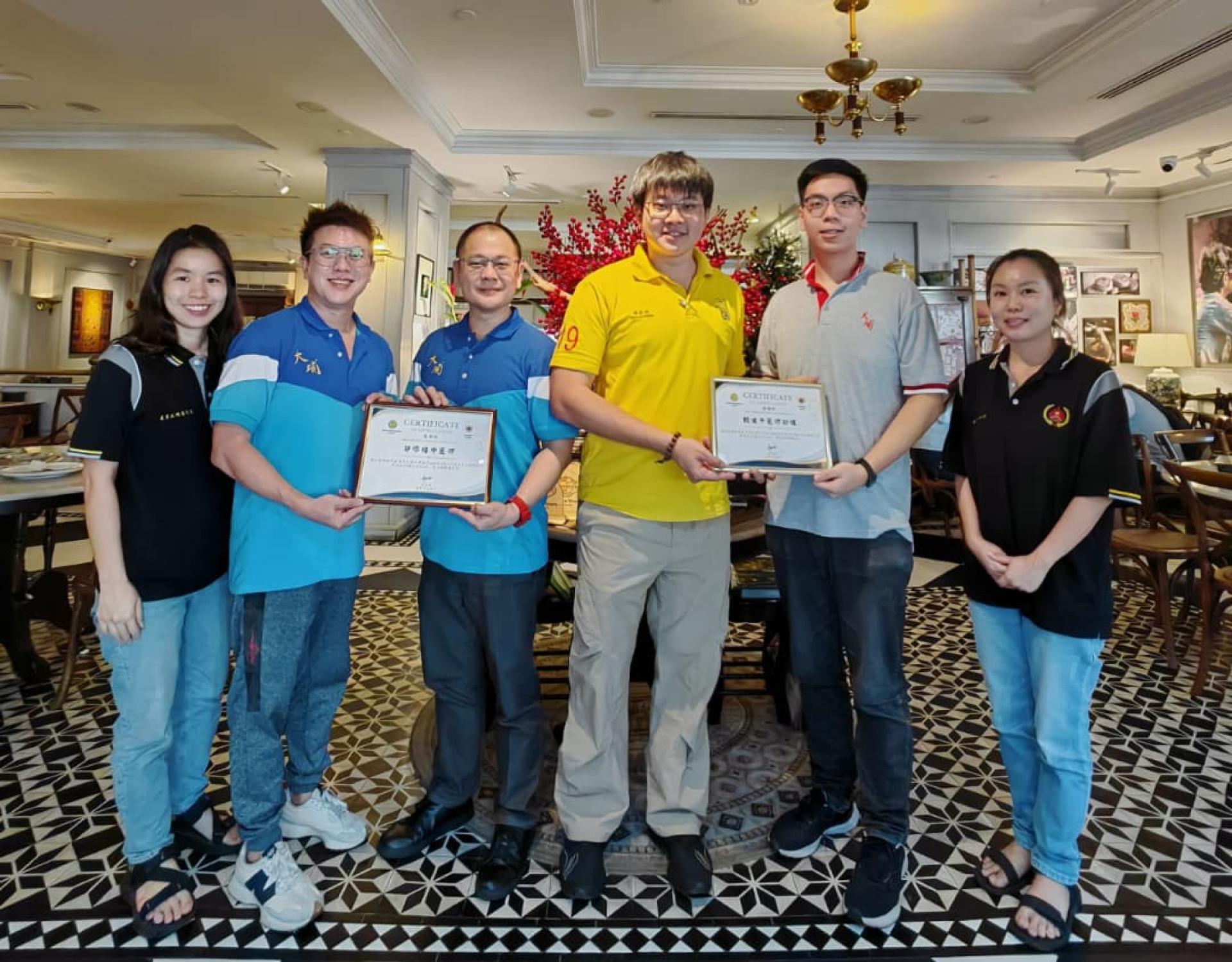 美里大埔同乡会青年团团长谢家洪（右3）及马来西亚大埔（茶阳）社团联合总会青年团总团长兼筹备会主席朱景祥（左2），联合移交感谢状予赖健平医师助理及鄔添禧医学博士后合影。