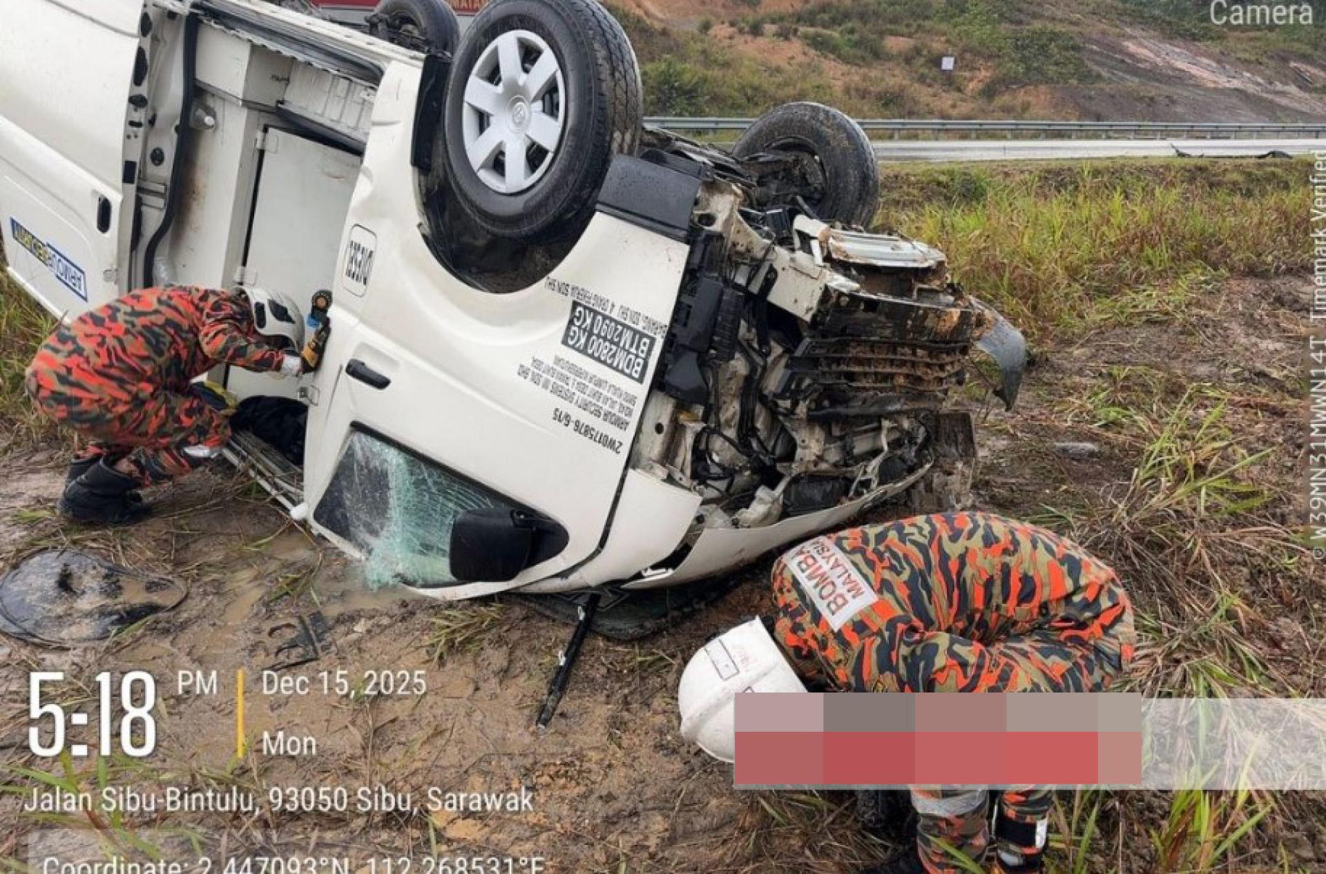 消防员评估翻覆的面包车情况。