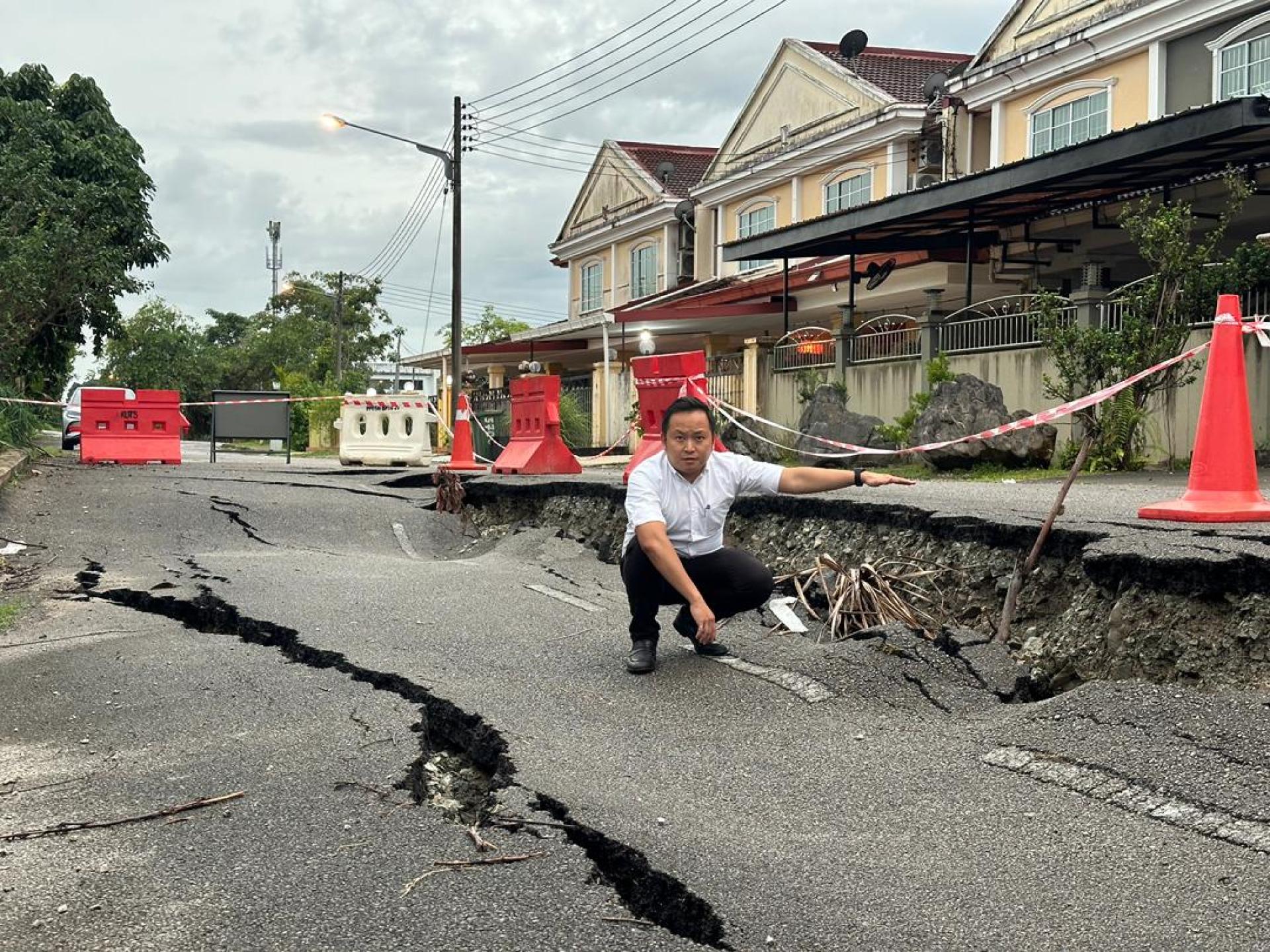 江峰年指着已经下沉严重的路段，并呼吁地方当局即刻采取行动解决。