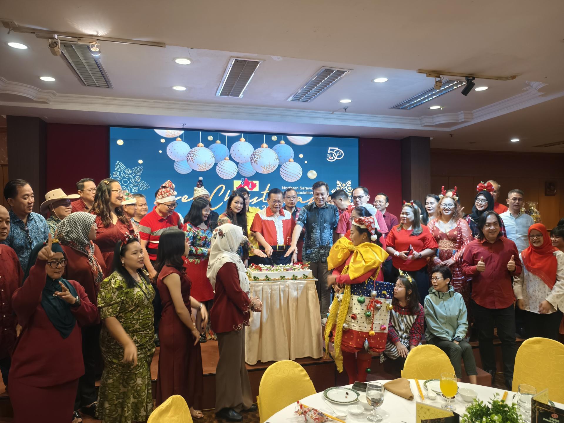 北砂新闻从业员协会2025年预庆圣诞节联欢会切蛋糕仪式，主宾砂拉越交通部长拿督斯里李景胜、嘉宾与会员齐聚一堂合影留念，场面温馨热闹。