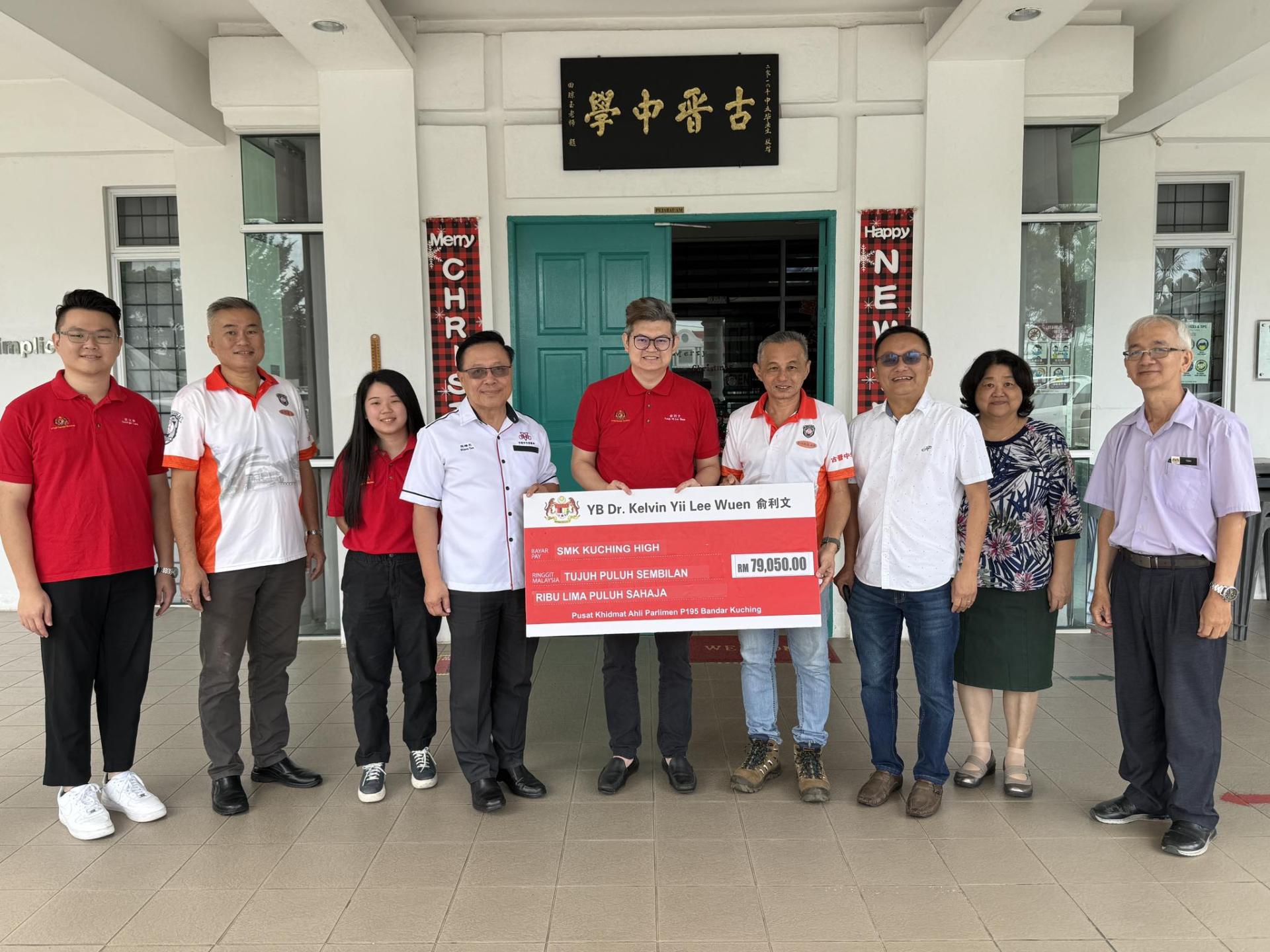 古晋市国会议员俞利文（中）移交其选区拨款7万9050令吉予古晋中学，作为该校礼堂LED屏幕舞台墙安装工程的经费。