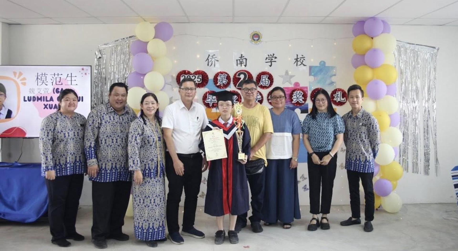 荣获模范生的魏艾萱与董事、校长老师合影。