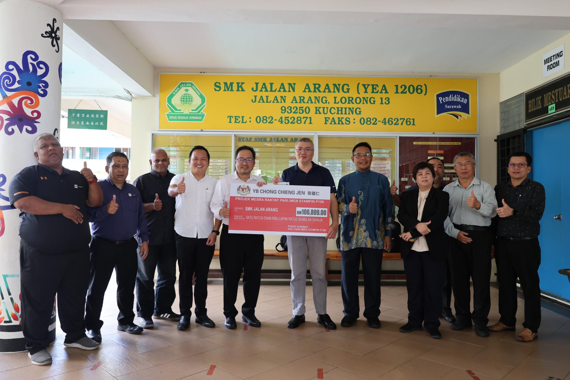 张健仁（左5）在众人的陪同下，移交拨款支票予煤炭路国中家协主席杨敬木（前右5）。左3及4分别是张健仁助理约翰及特别助理江峰年。前右3为校长黄玉真。