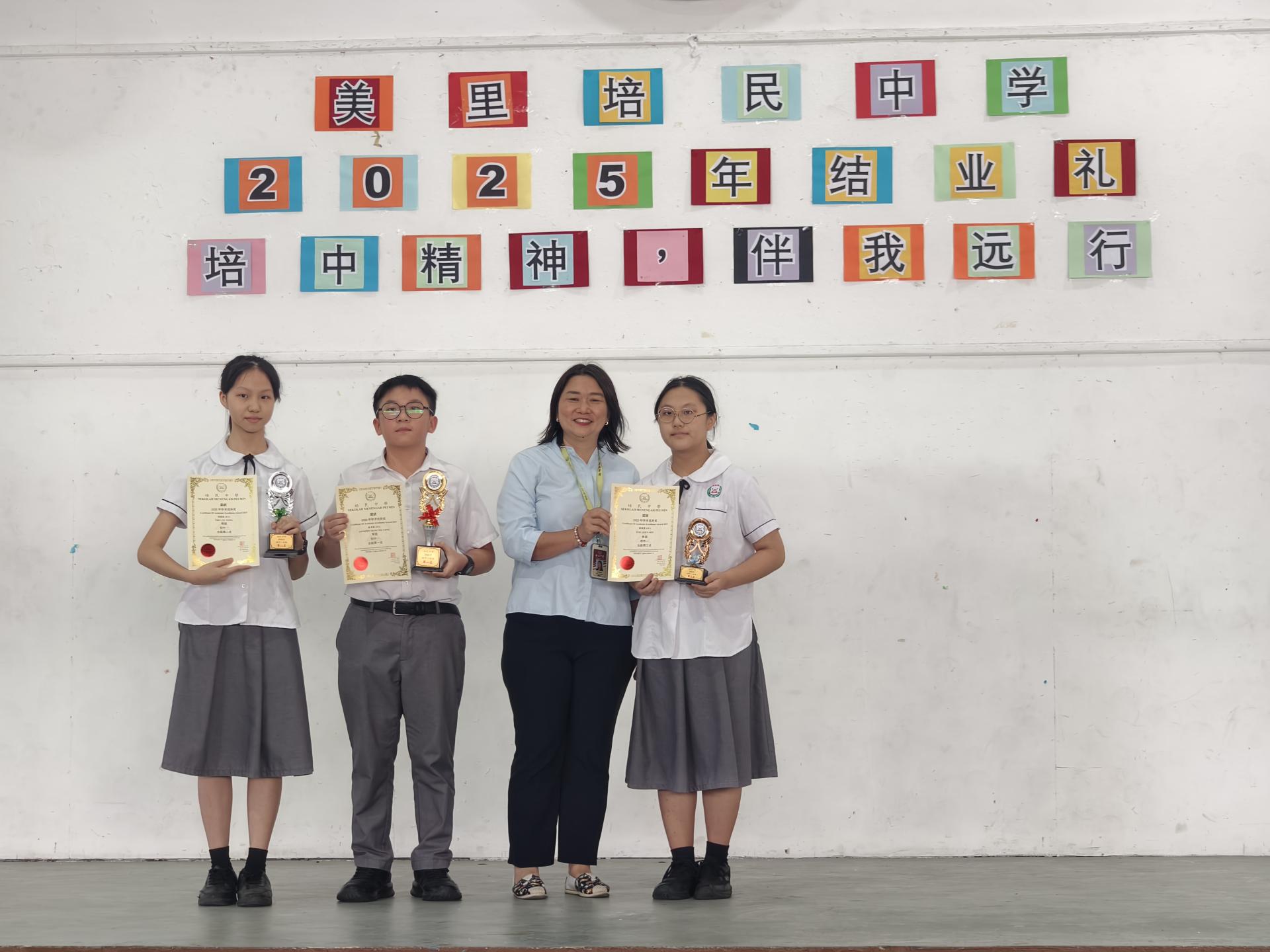 美里培民中学校长贝美娇（左3）颁发奖状给全级成绩首三名最优秀的学生，以示鼓励。