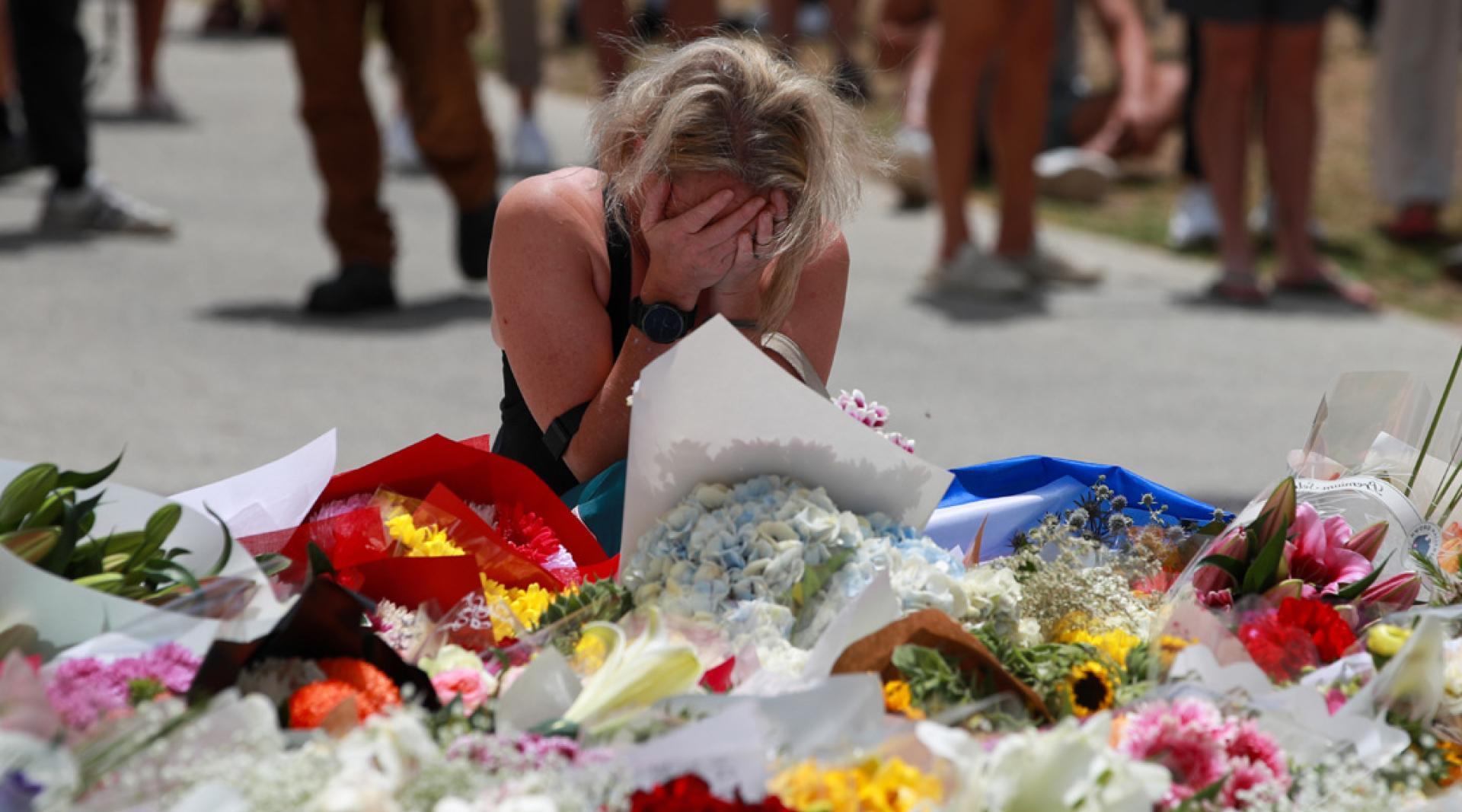 女子15日在邦迪滩枪击事件现场附近悼念遇难者。（图：新华社）