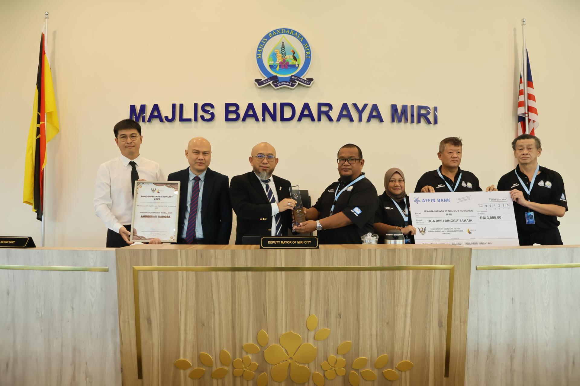 美里市政局居民巡逻委员会将在2025年智慧社区奖项评选中荣获铜奖殊荣移交给美里市政局，由副市长阿里芬（左3）接领。