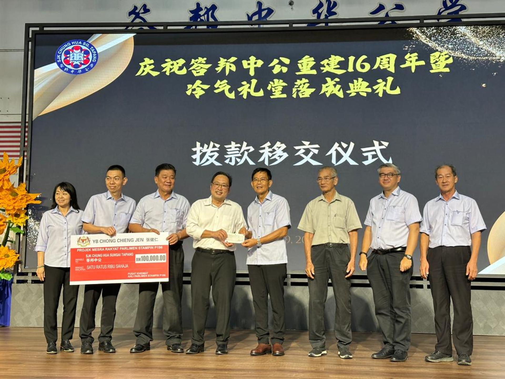 主宾张健仁（左4）在一众校董会理事陪同下，移交10万令吉礼堂提升工程拨款及李氏基金会15万令吉精明课室拨款予校董会主席刘天亮（右4）。左起为校董会秘书罗绍凤、财政罗容惠及副主席田福；右起则为副主席蔡美仁、署理主席许礼美及副主席黄南基。