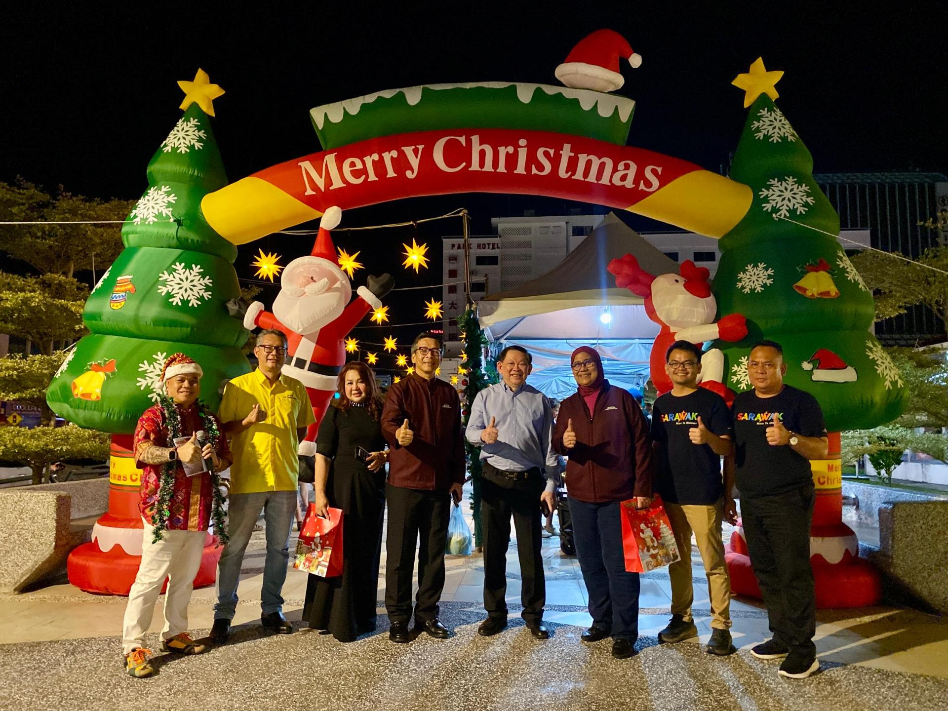 贵宾们在圣诞市集前合影。左2起为市长俞小珊的代表余忠明市议员、拿督丹尼斯敖伉俪，右3为砂拉越旅游局首席执行员莎孜德。