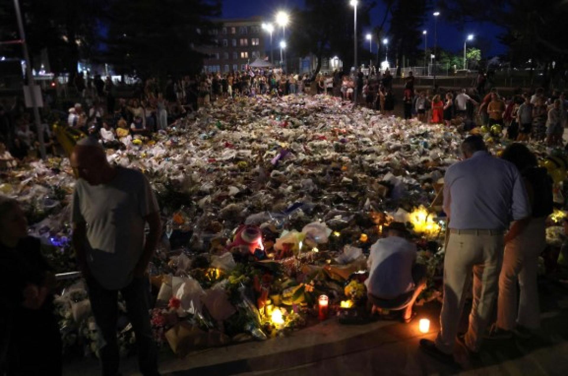 悉尼邦迪海滩附近的悼念场合，20日晚摆满花束。