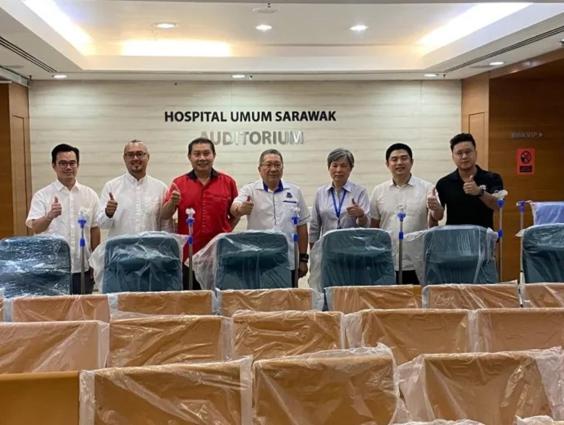 黄鸿圣（中）与Dr Ngian Hie Ung（右3）在交付捐赠椅子后合影。