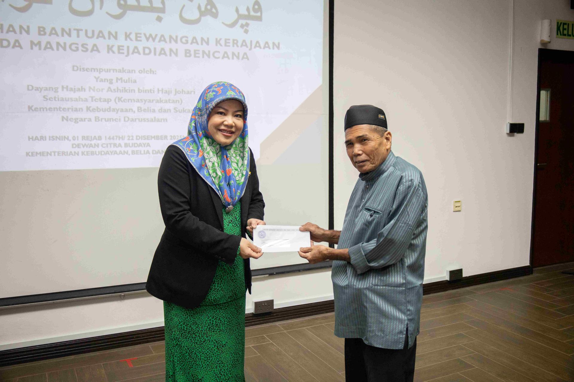 文化、青年和体育部常任秘书（社区事务）兼社会发展局代局长诺尔阿什金移交援助金予灾黎