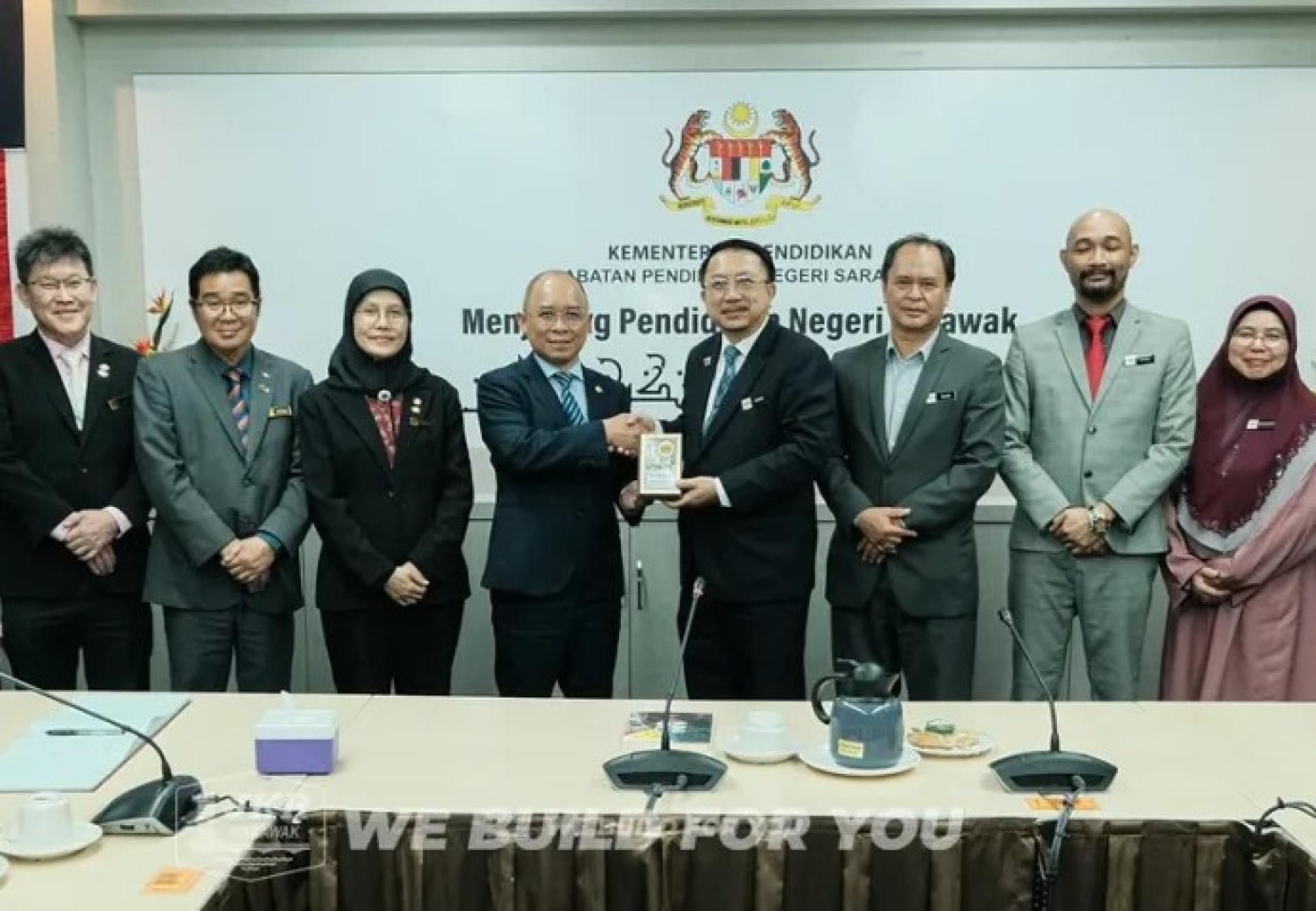 卡西迪（左4）于2025年12月22日礼节性访问砂拉越教育局时，向奥玛赠送纪念品。