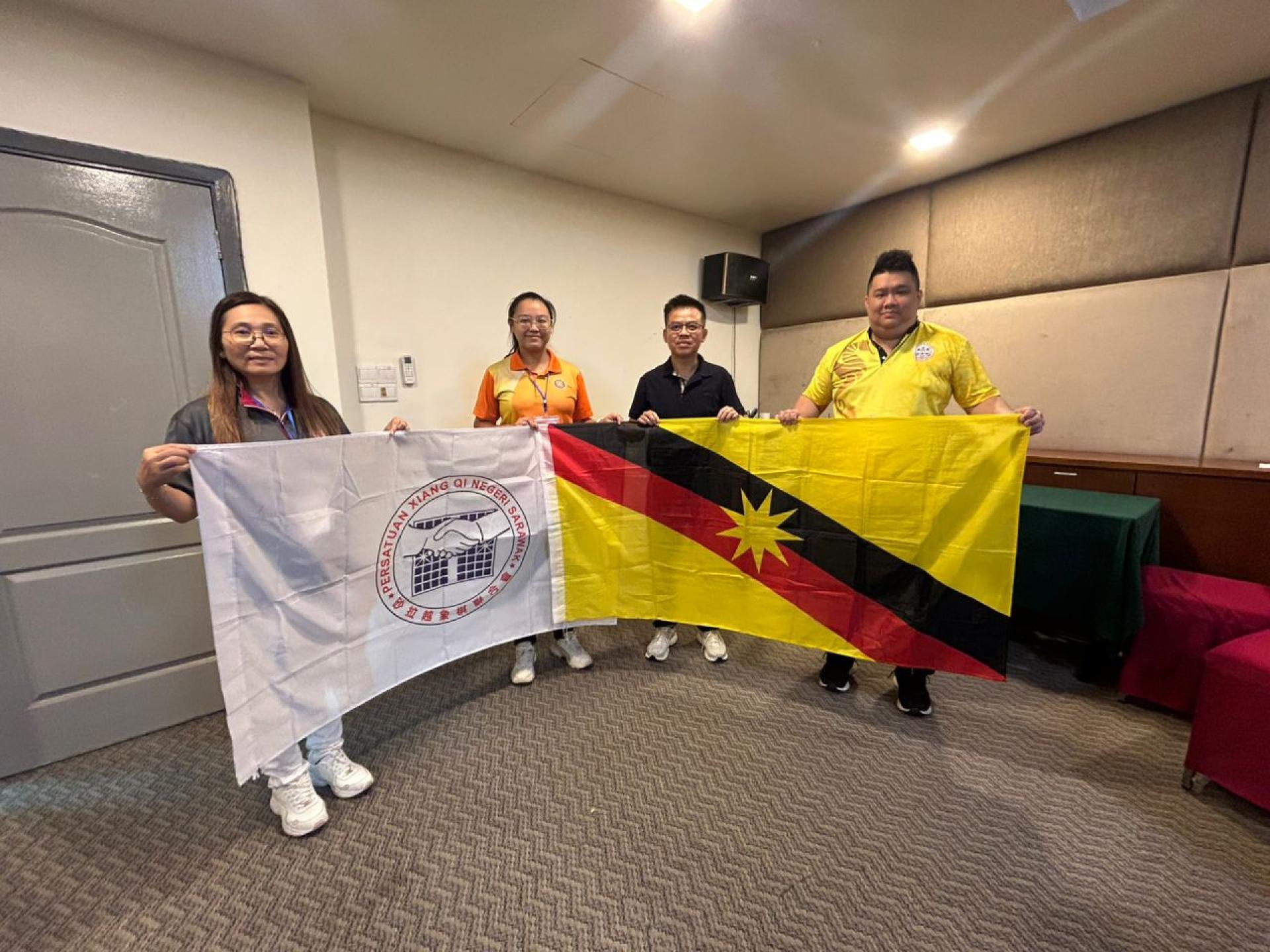 砂拉越象棋联合会主席陈宗义（右2）授旗于领队黄义熙（右1）。左起为三马拉汉省象棋公会主席刘杏华及古晋象棋公会主席余欣如