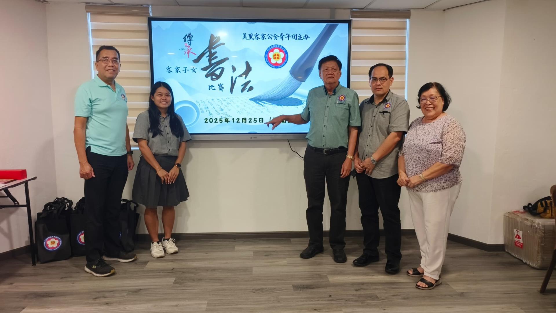 美里客家公会主席江先柱的代表兼副主席黄能喜为美里客家公会青年团举办2025年客家子女传承书法比赛主持开幕揭题礼。左起为秘书长杨春德，筹备主席刘丽美；右起为副主席杨绣莲及青年团团长杨万勇。