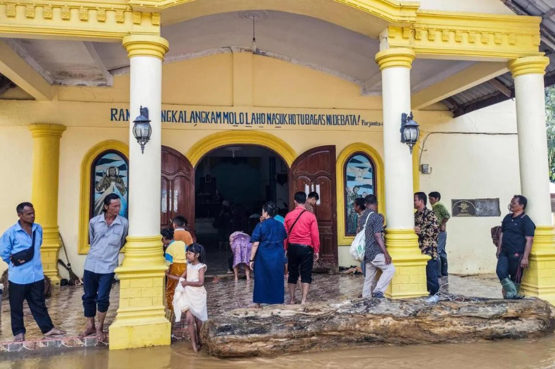 北苏门答腊省中打巴奴里县一个村子的灾民星期三（12月24日）从临时避难所回到他们所属的教会，参加平安夜弥撒。苏门答腊岛11月底发生的洪灾和山体滑坡，将许多居民区夷为平地，目前有至少1129人死亡。