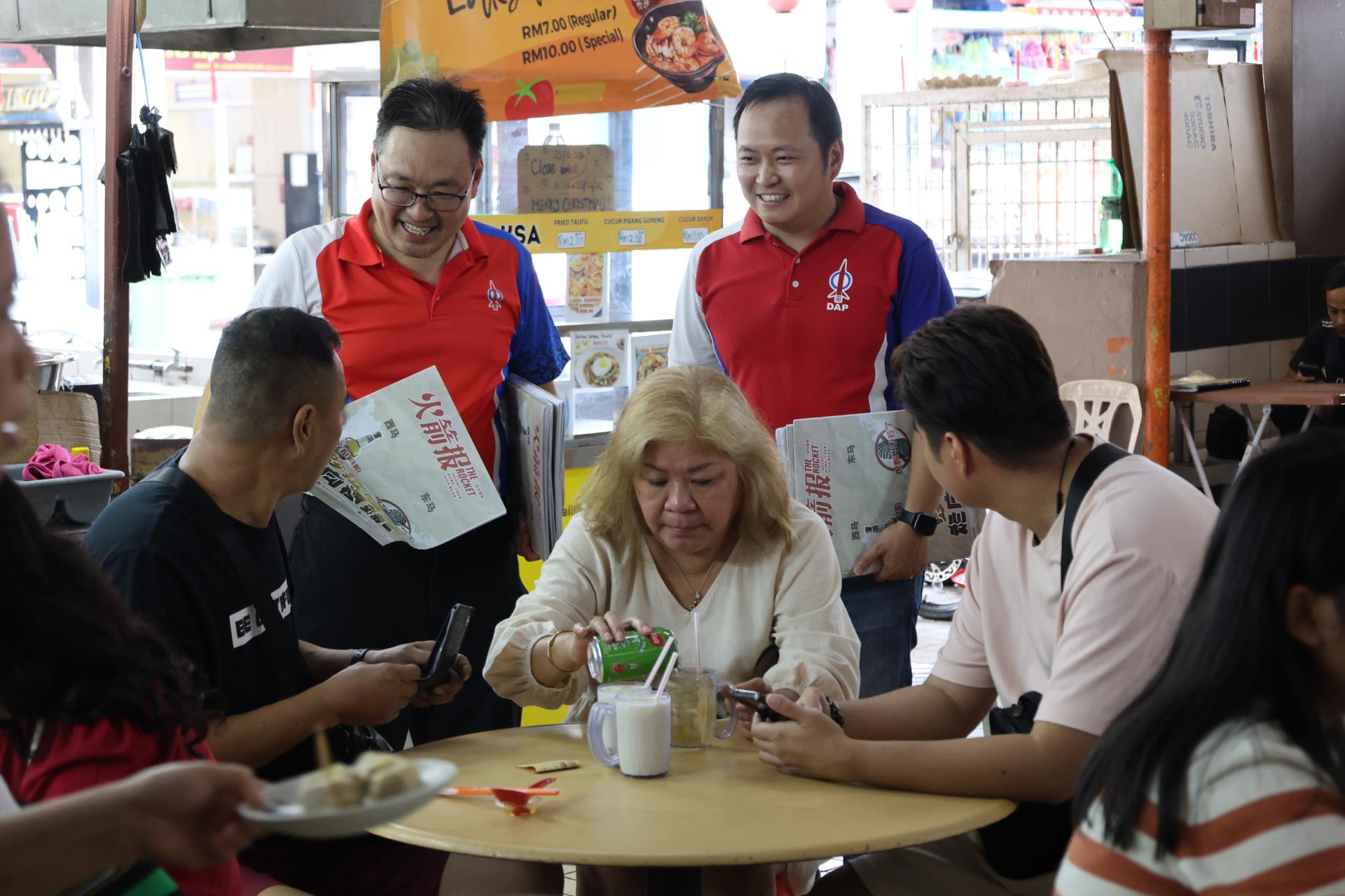 张健仁率领团队走访古晋老巴刹推销《火箭报》和分发2026年年历。