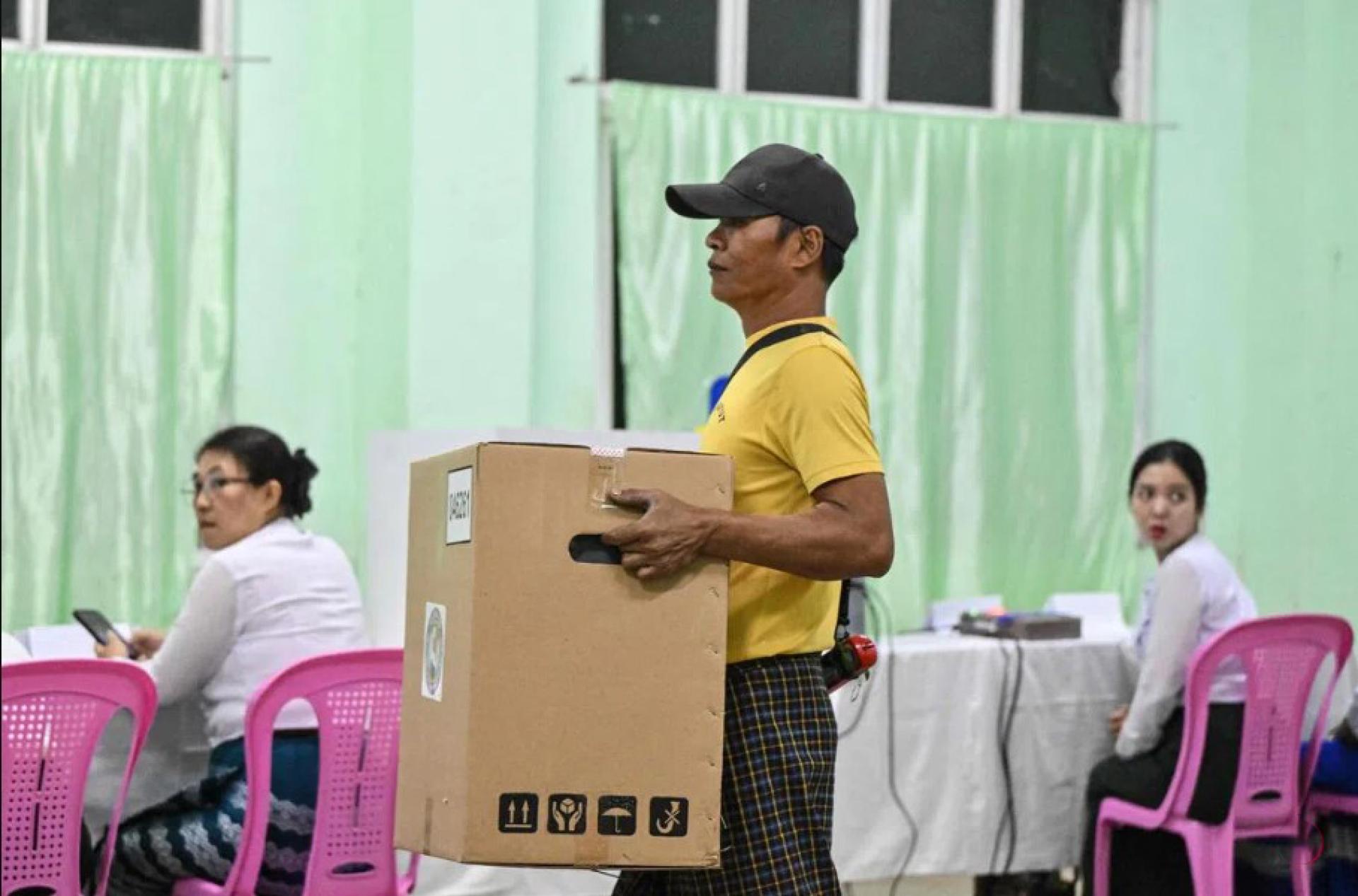 缅甸大选12月28日开启首轮投票，联邦选举委员会人员在仰光一个投票站进行准备工作。