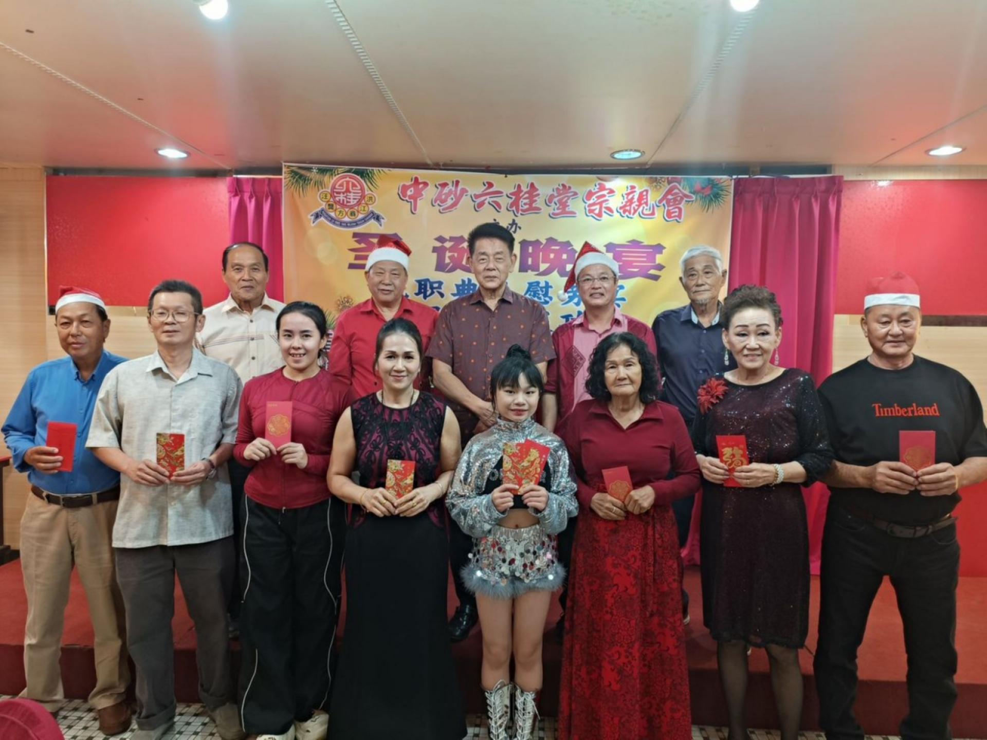 主宾马拉端区立法议员拿督陈冠勋（后排中）颁发歌赛优胜者奖项后与主办当局合影。左起为本曼查俞希善、中砂六桂堂宗亲会主席江宗兴；右起是姓氏歌赛筹委主席江国逸、圣诞晚会筹委主席翁新达。