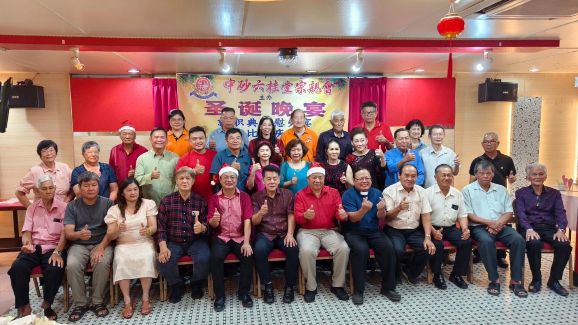 主宾马拉端区立法议员拿督陈冠勋（前排左6起）与砂中区六桂堂宗亲会主席江宗兴、圣诞节晚会筹委及会员合影。左5为筹委主席翁新达、本曼查俞希善等人。